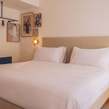 a bed with white sheets and pillows