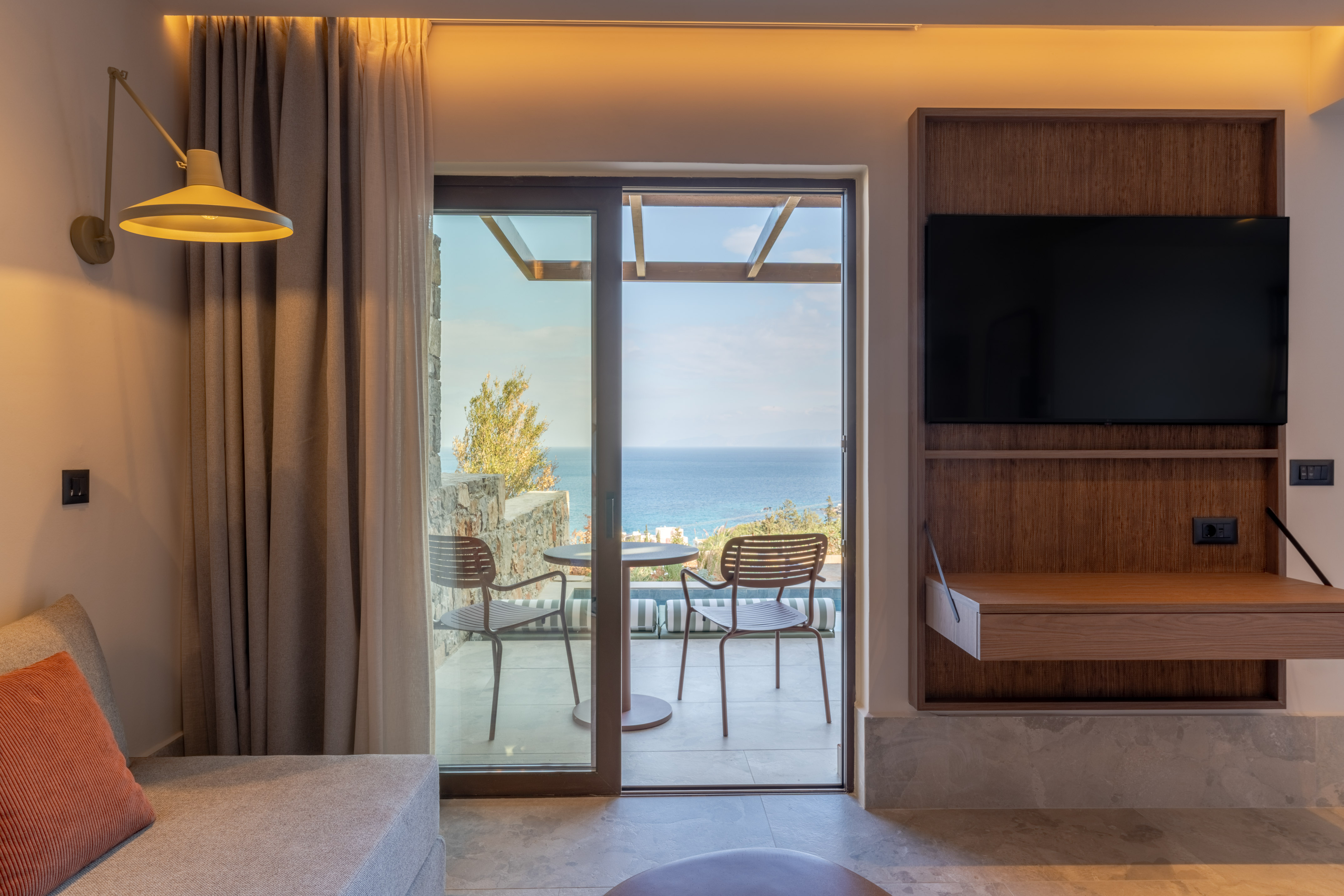 Hotel room with ocean view balcony and modern interior design.