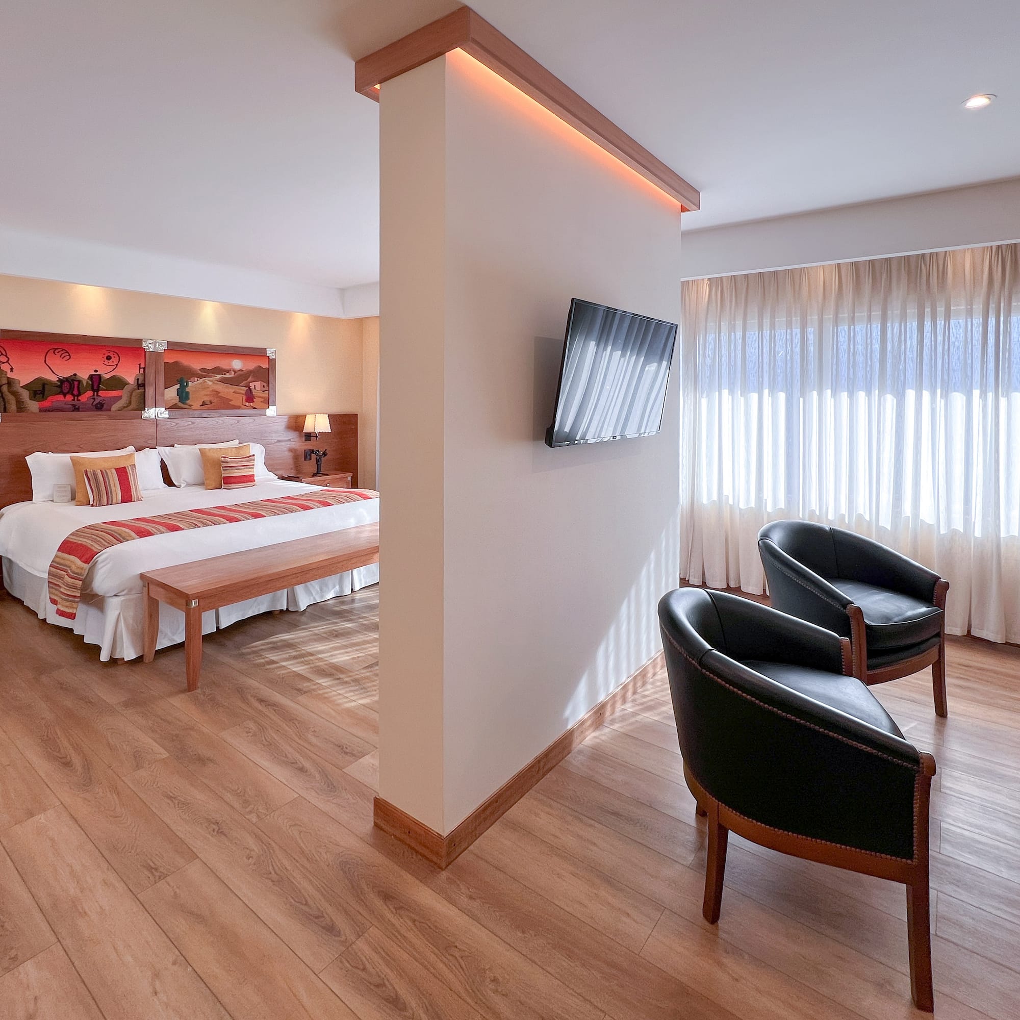 a room with a bed and two chairs