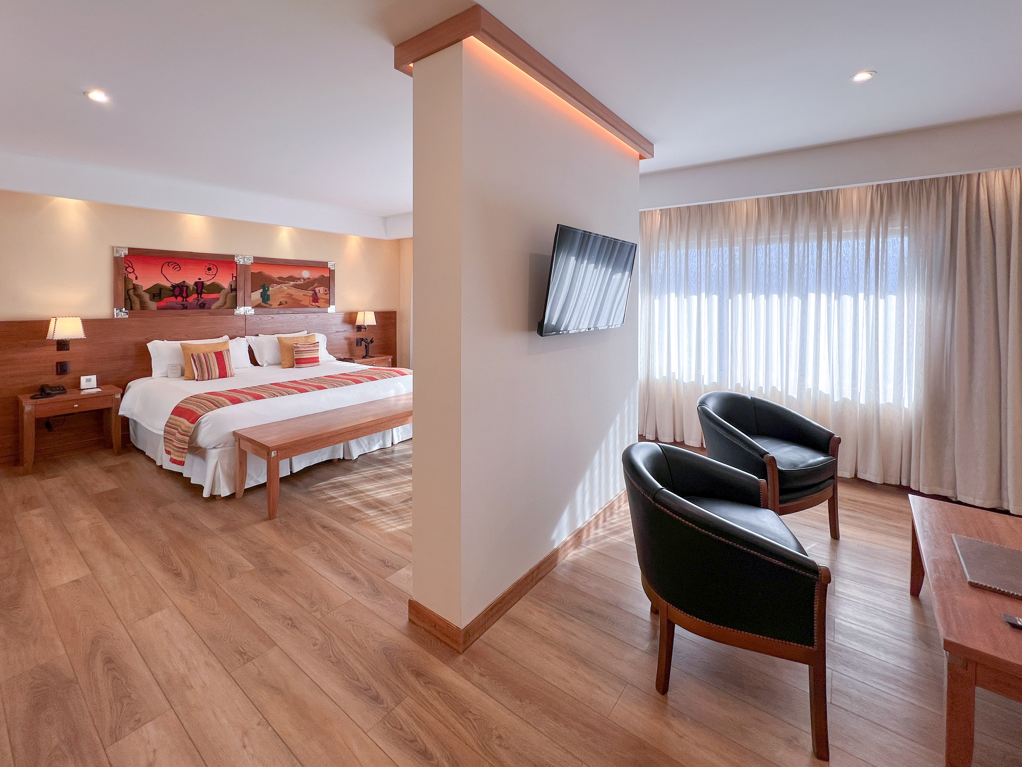 a room with a bed and two chairs