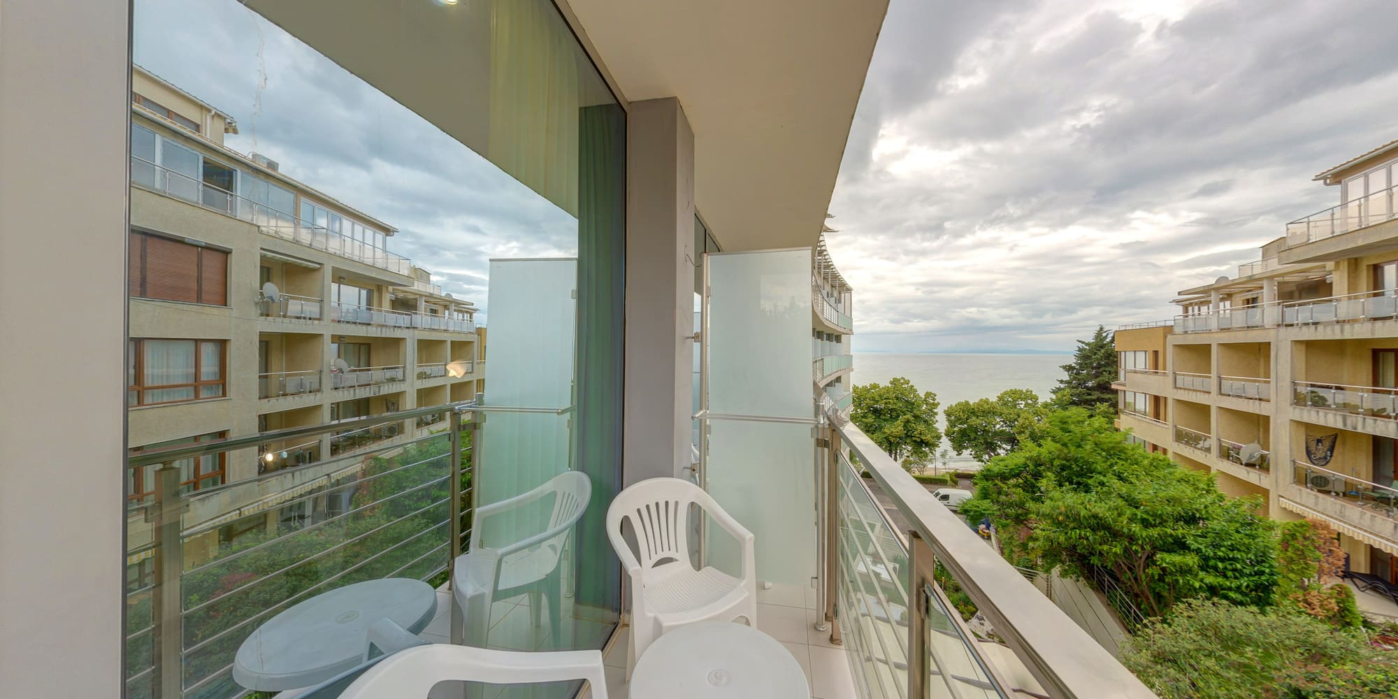 a balcony with chairs and a table