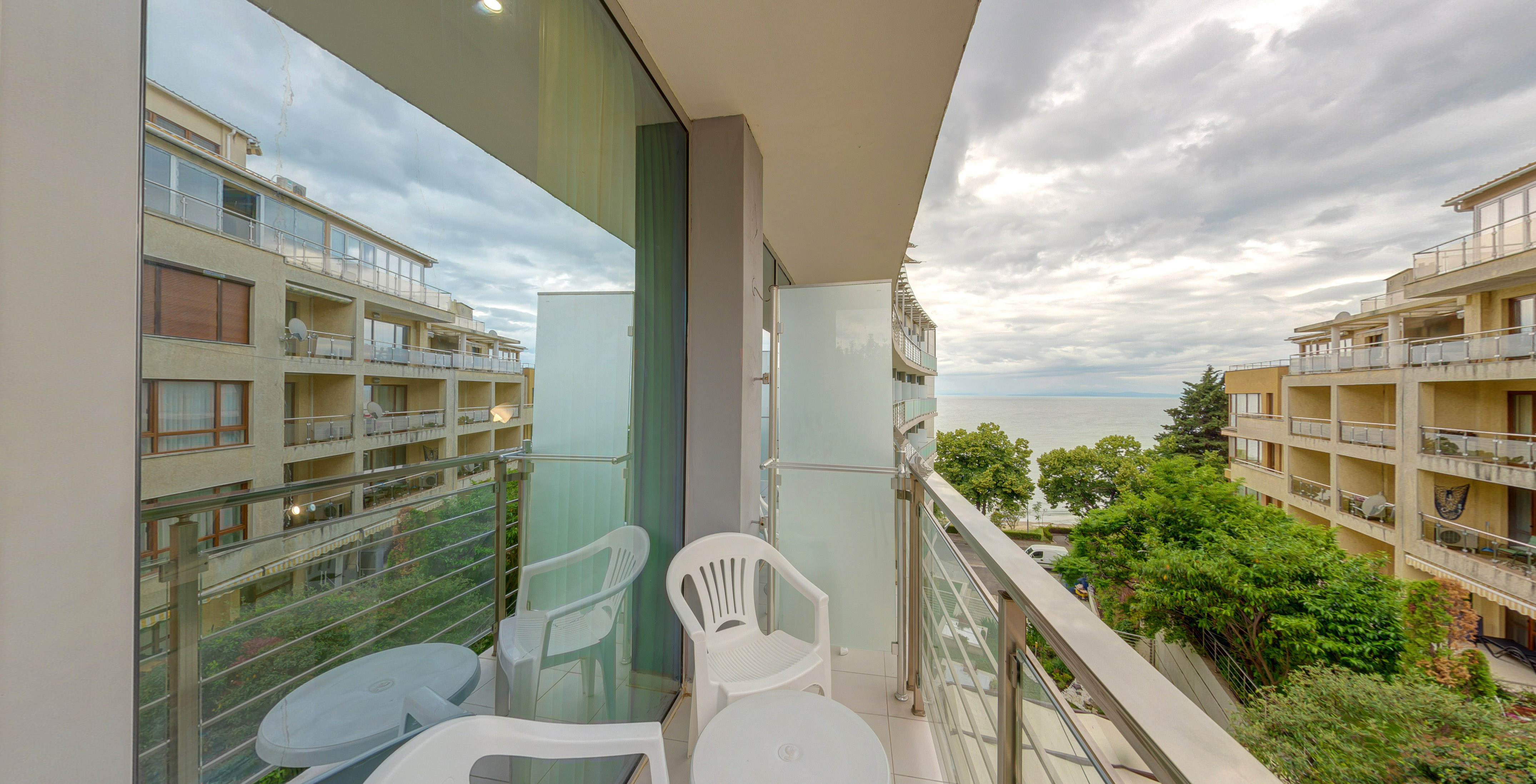 a balcony with chairs and a table