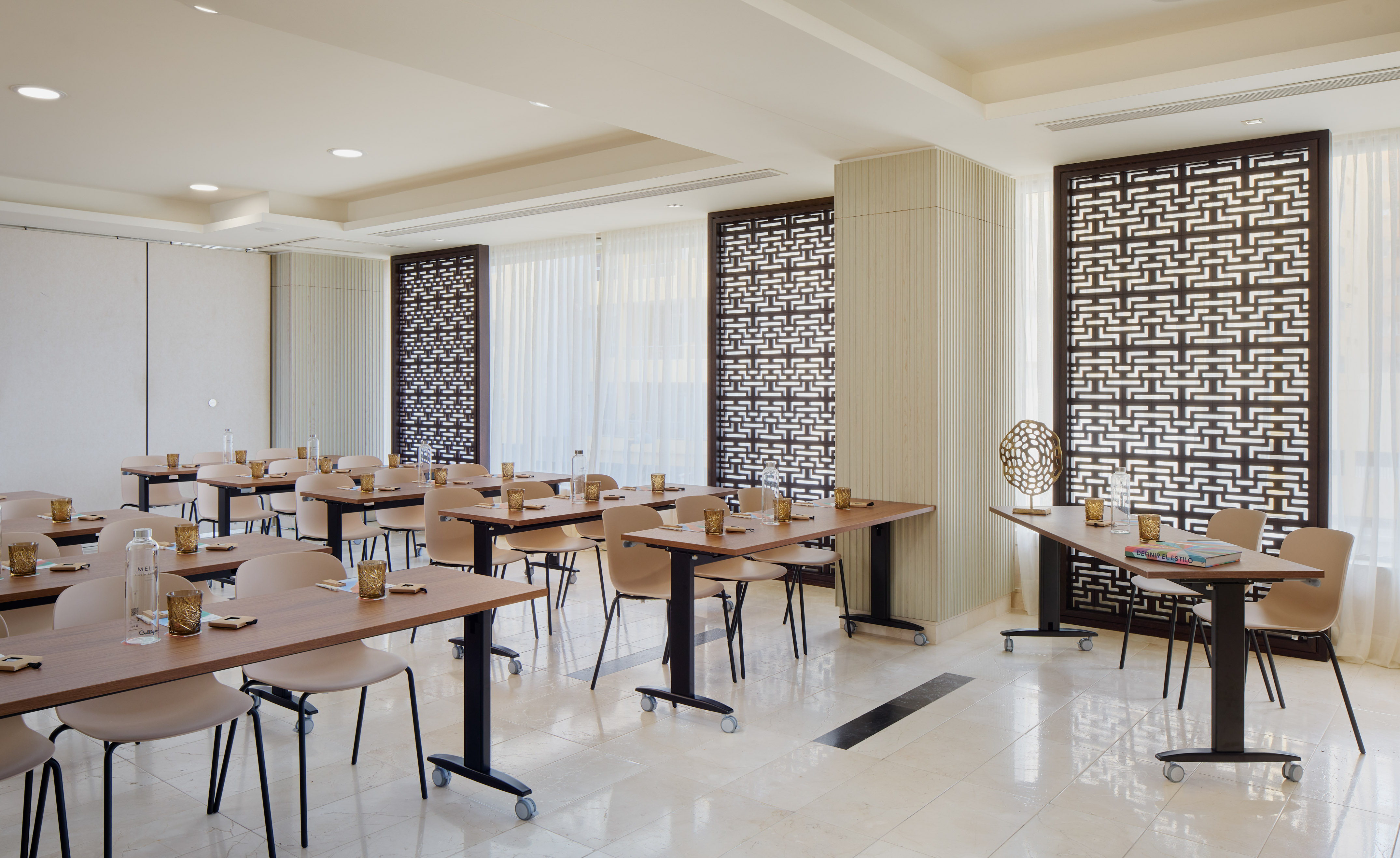 Modern meeting room, classroom setup, light tables, chairs, decorative screens.