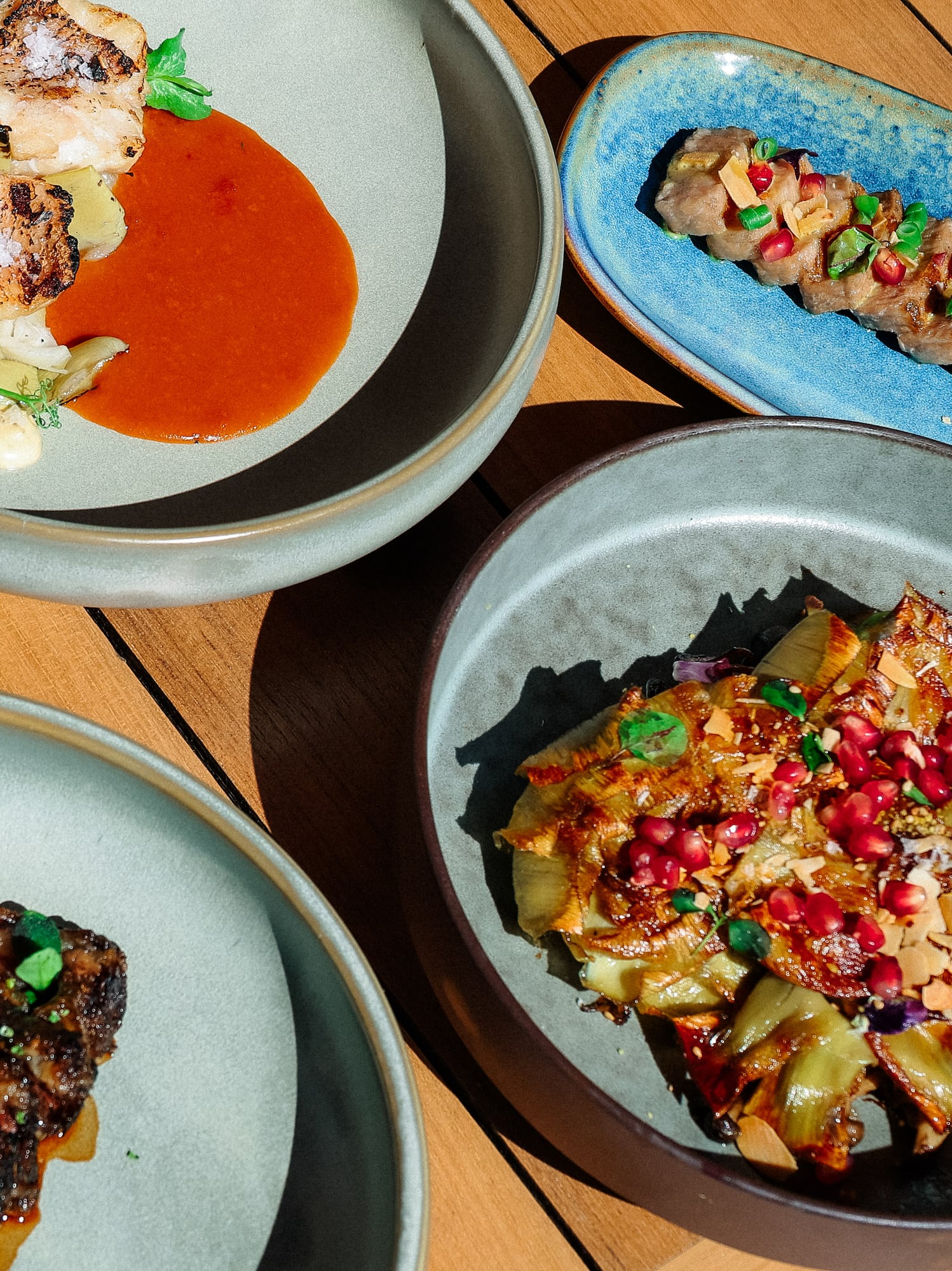 Restaurant dining: grilled fish, steak, sliced meat, pomegranate vegetables.