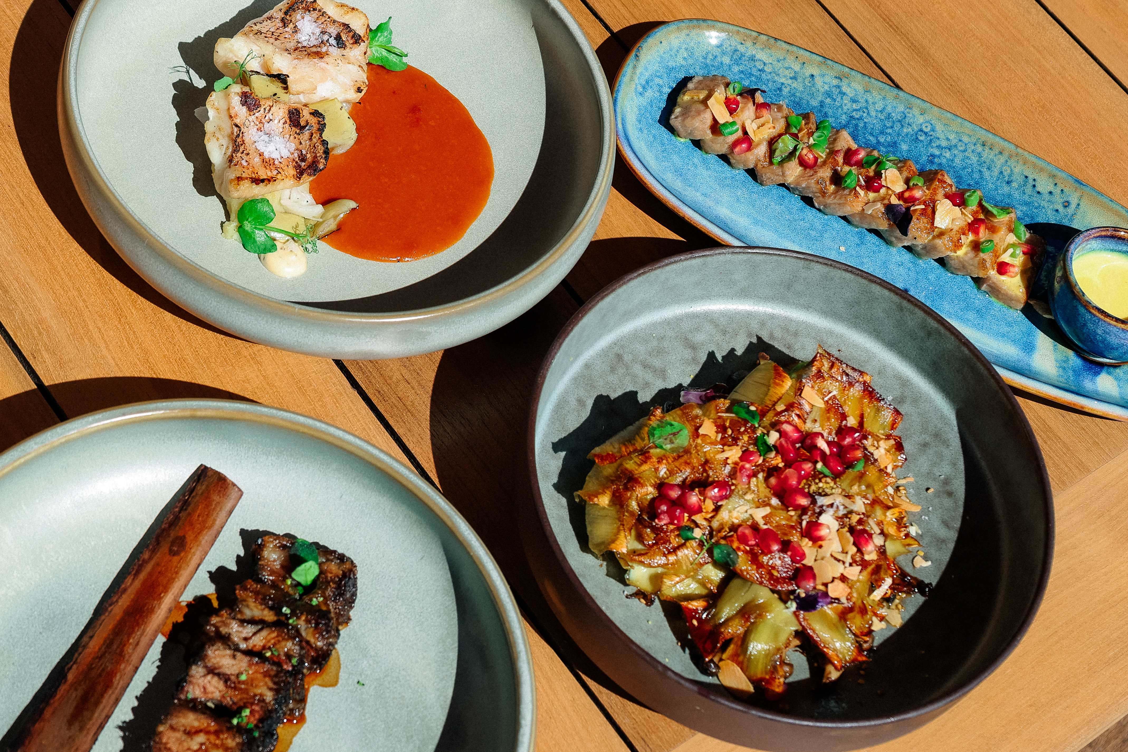 Restaurant dining: grilled fish, steak, sliced meat, pomegranate vegetables.