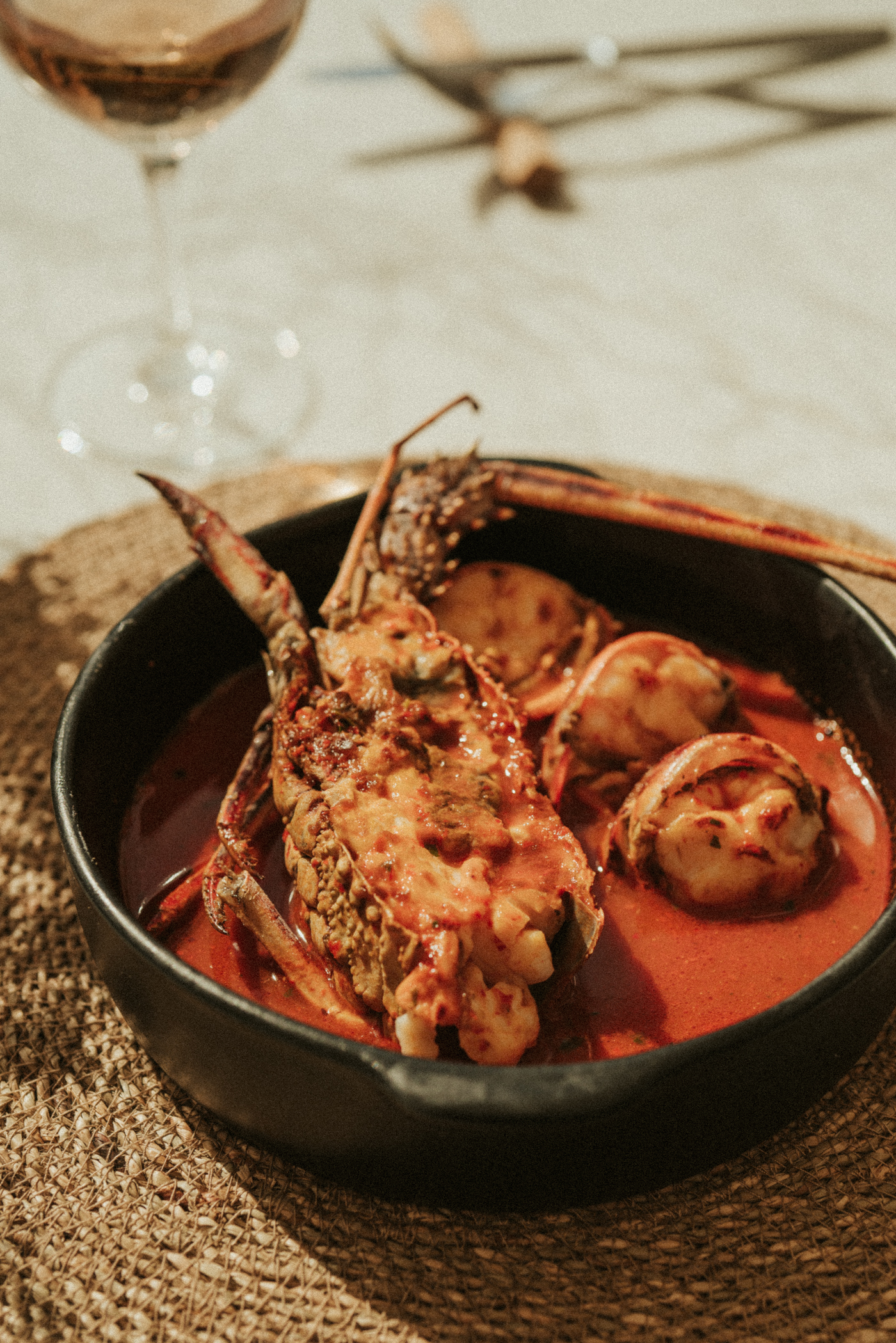 Spiny lobster and shrimp in red curry sauce, served with wine.