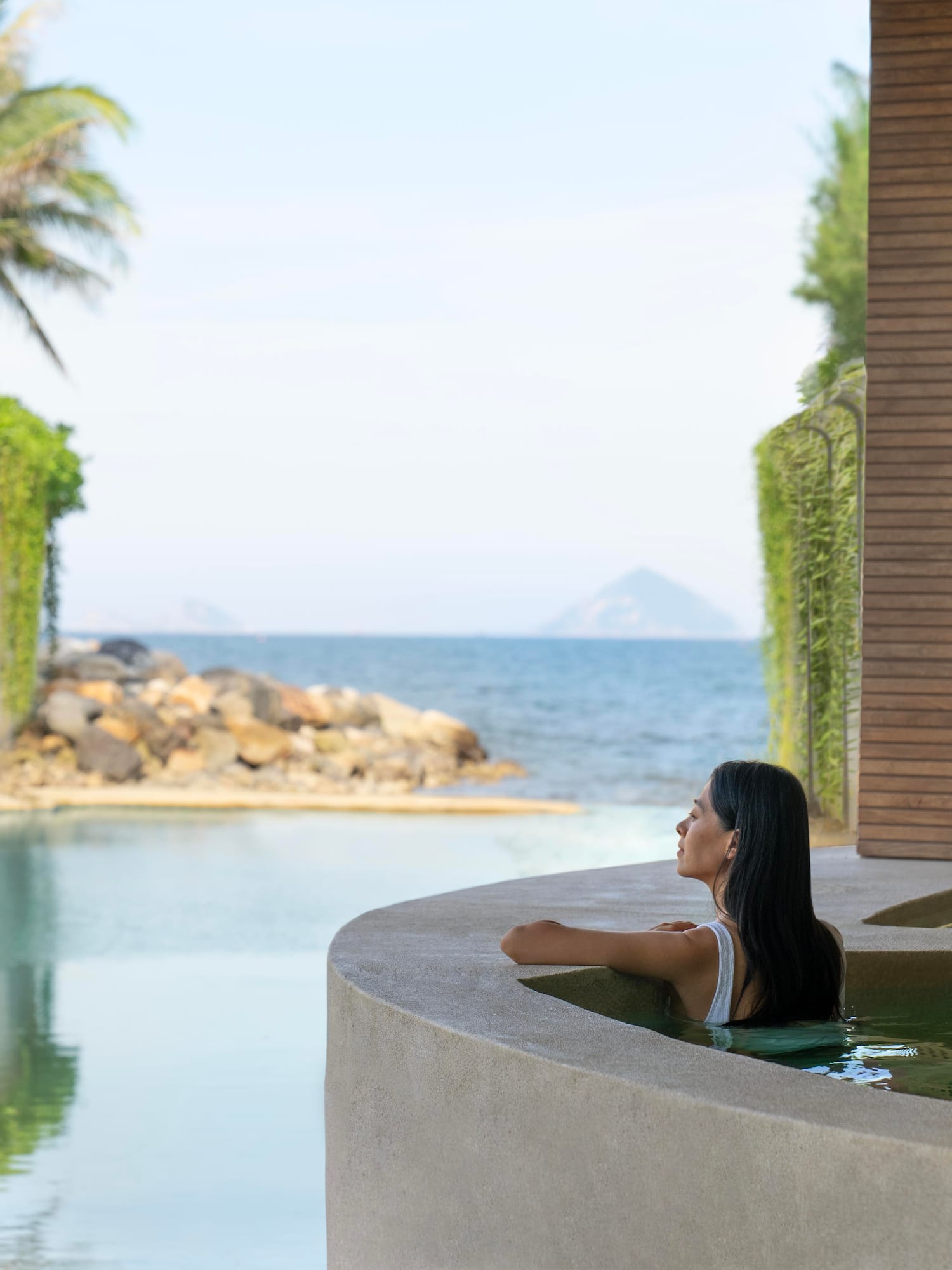 a woman in a pool looking out to the ocean
