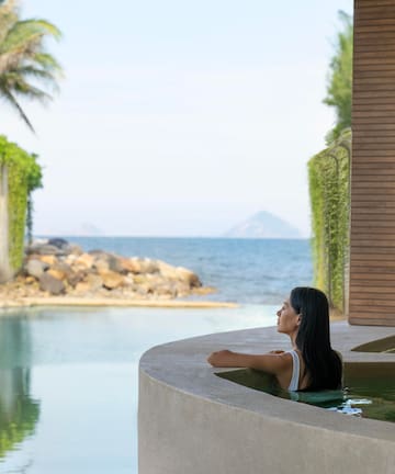 a woman in a pool looking out to the ocean