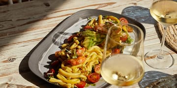 a plate of pasta and wine glasses on a table