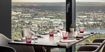 a table with wine glasses and a view of a city