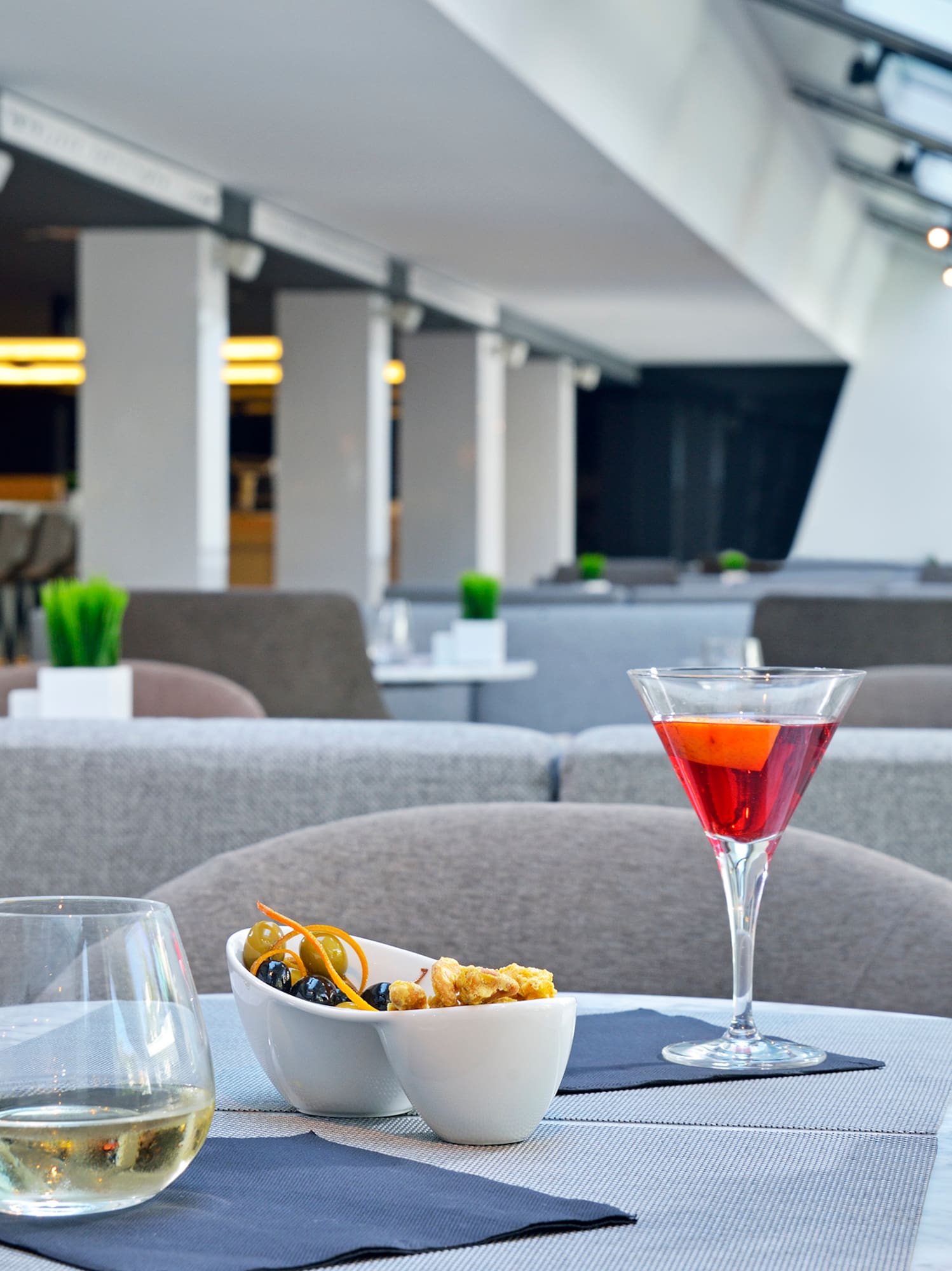 a table with a glass of wine and a bowl of fruit