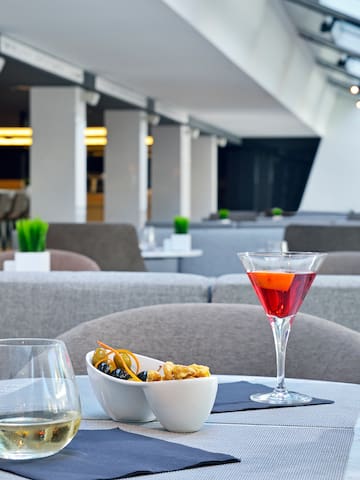 a table with a glass of wine and a bowl of fruit