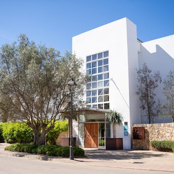 a white building with trees and bushes