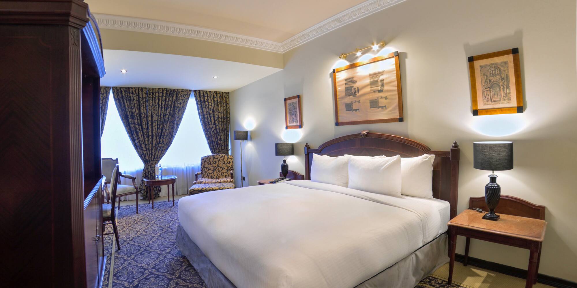 a room with a bed and chairs