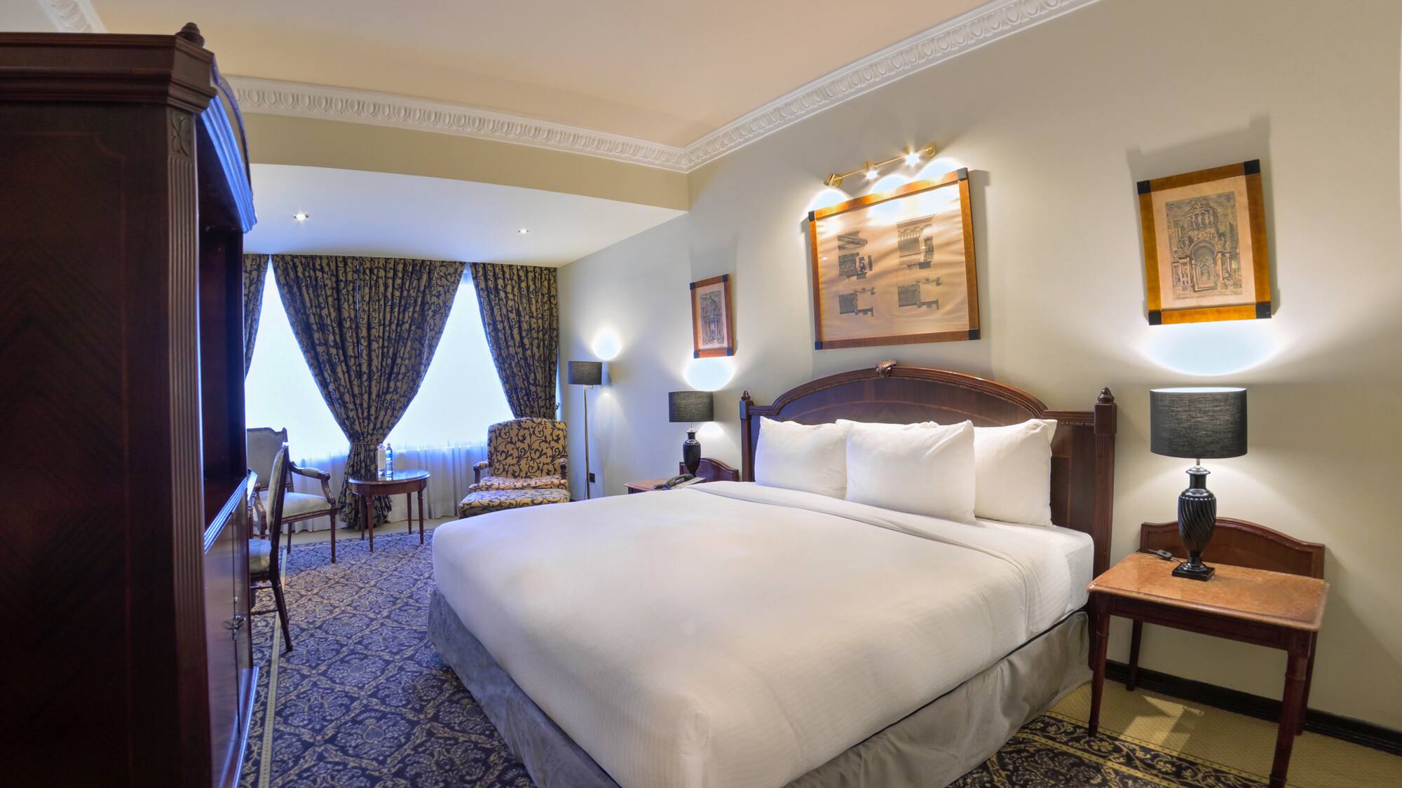 a room with a bed and chairs