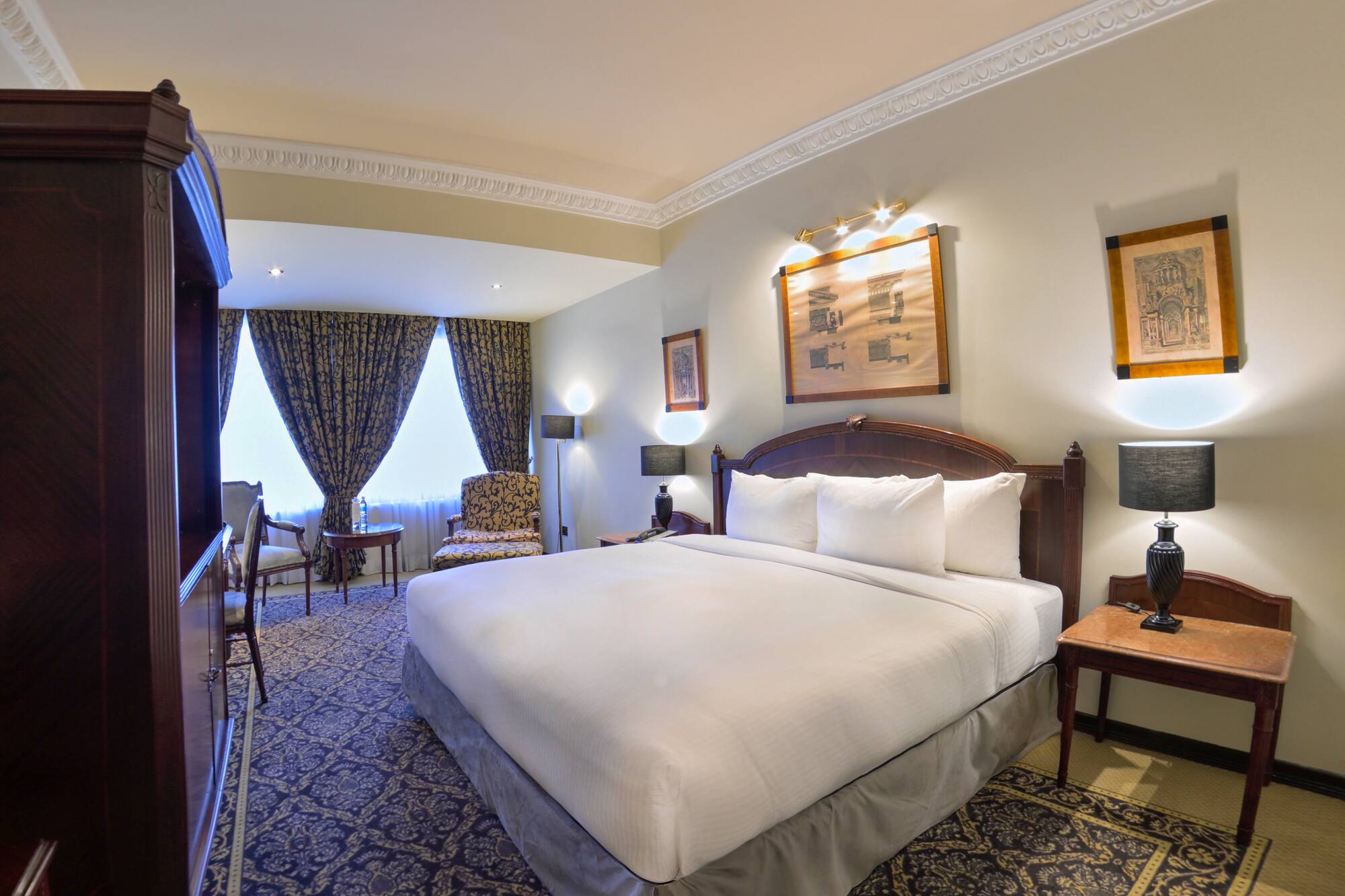 a room with a bed and chairs