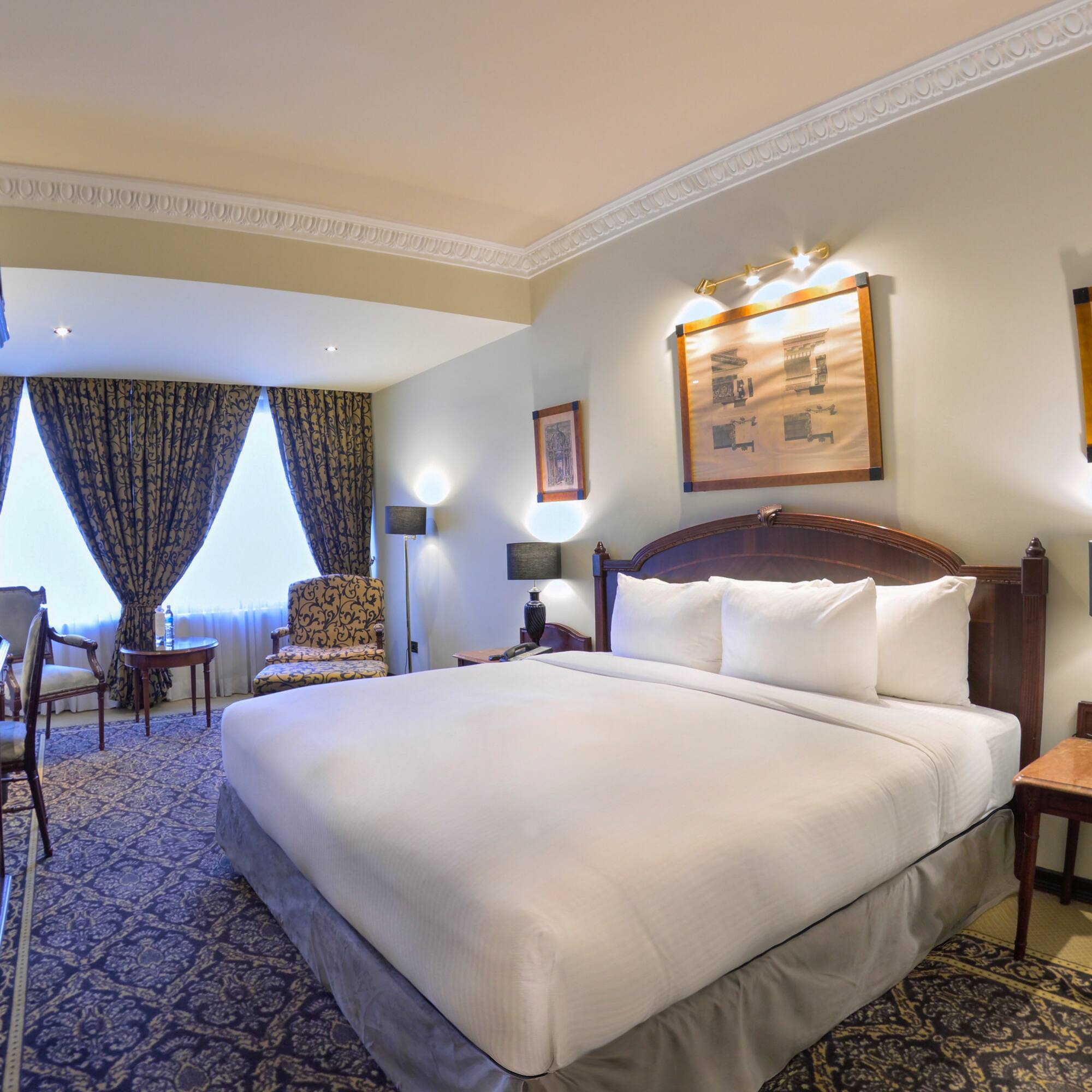 a room with a bed and chairs