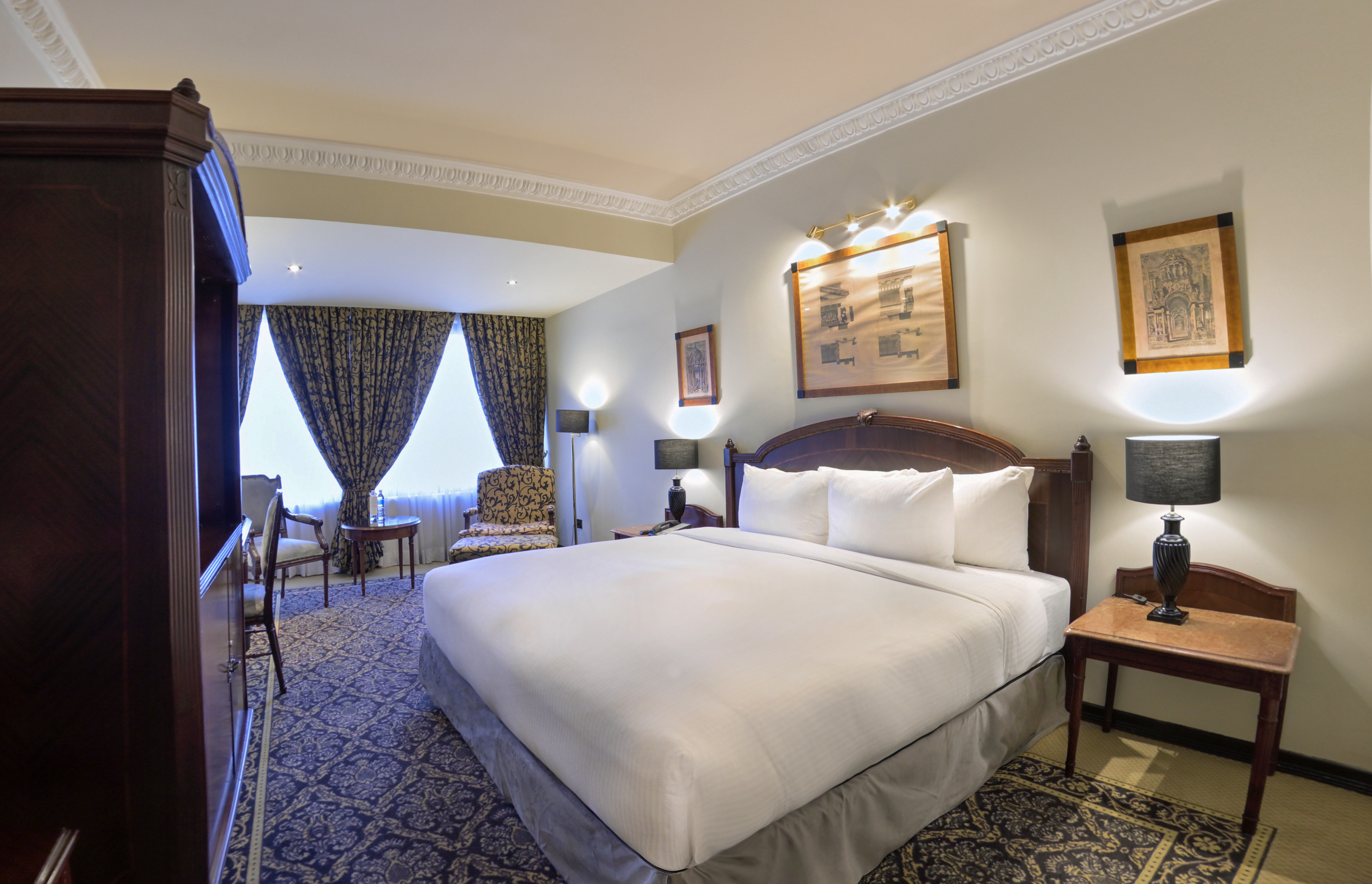 a room with a bed and chairs