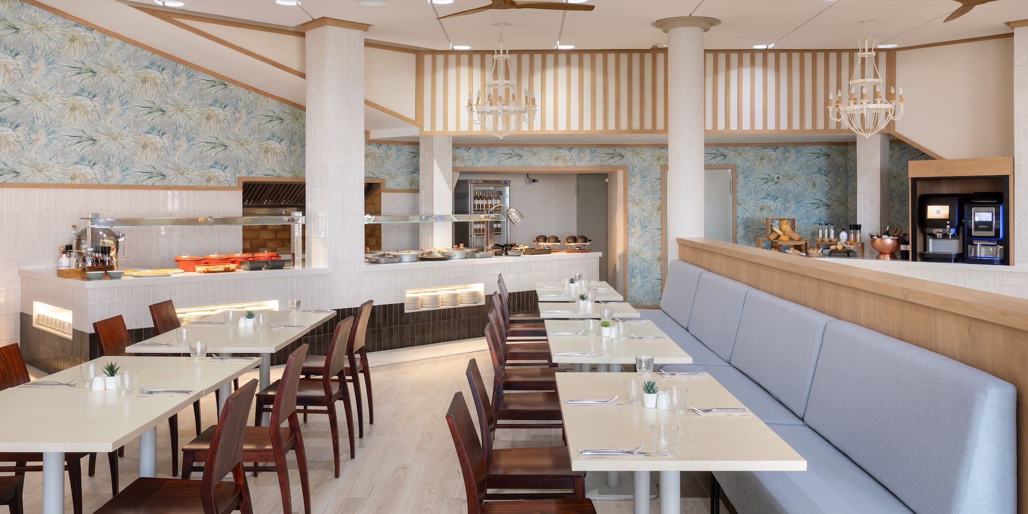 Hotel buffet restaurant with dining tables, banquette seating, and serving area.