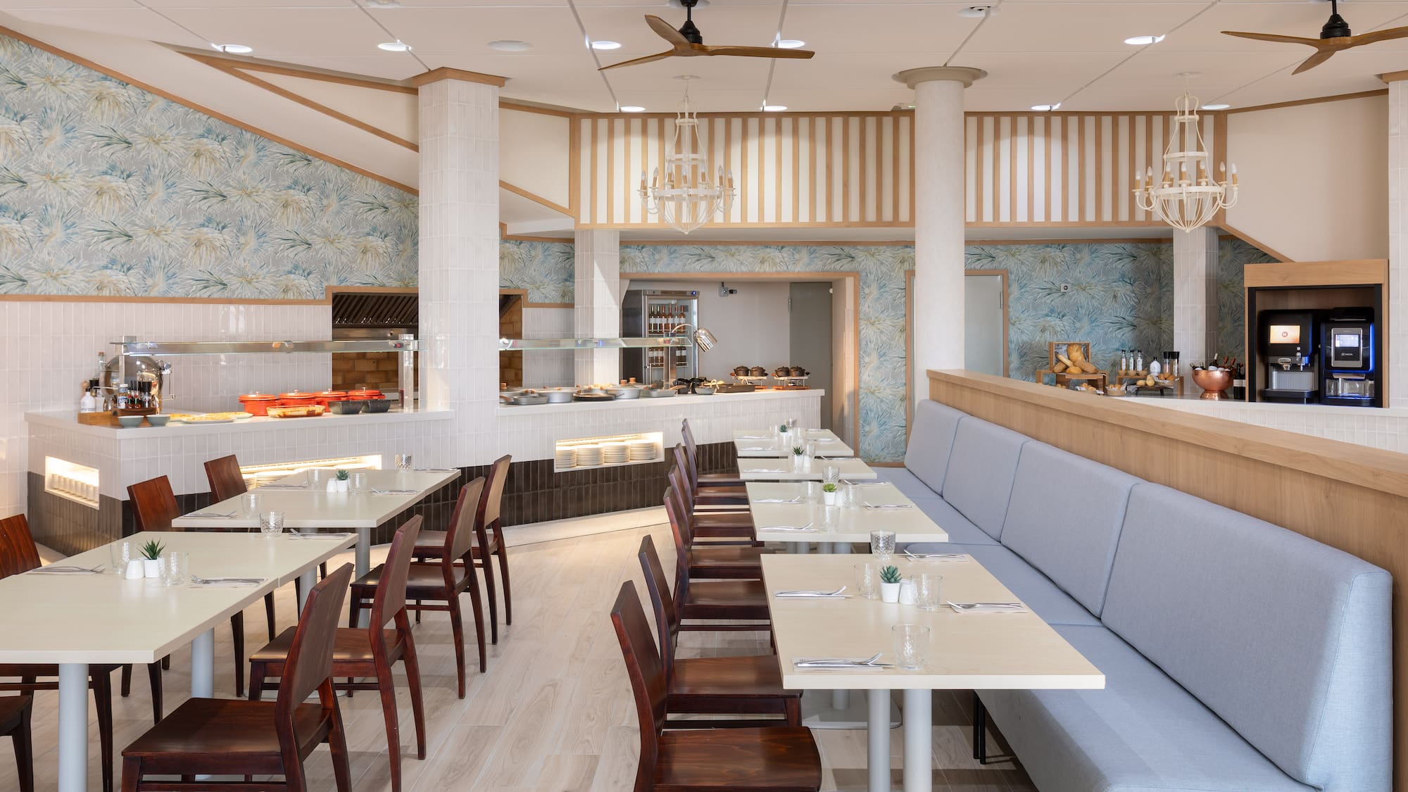 Modern hotel restaurant buffet with dining tables, chairs, and bench seating.