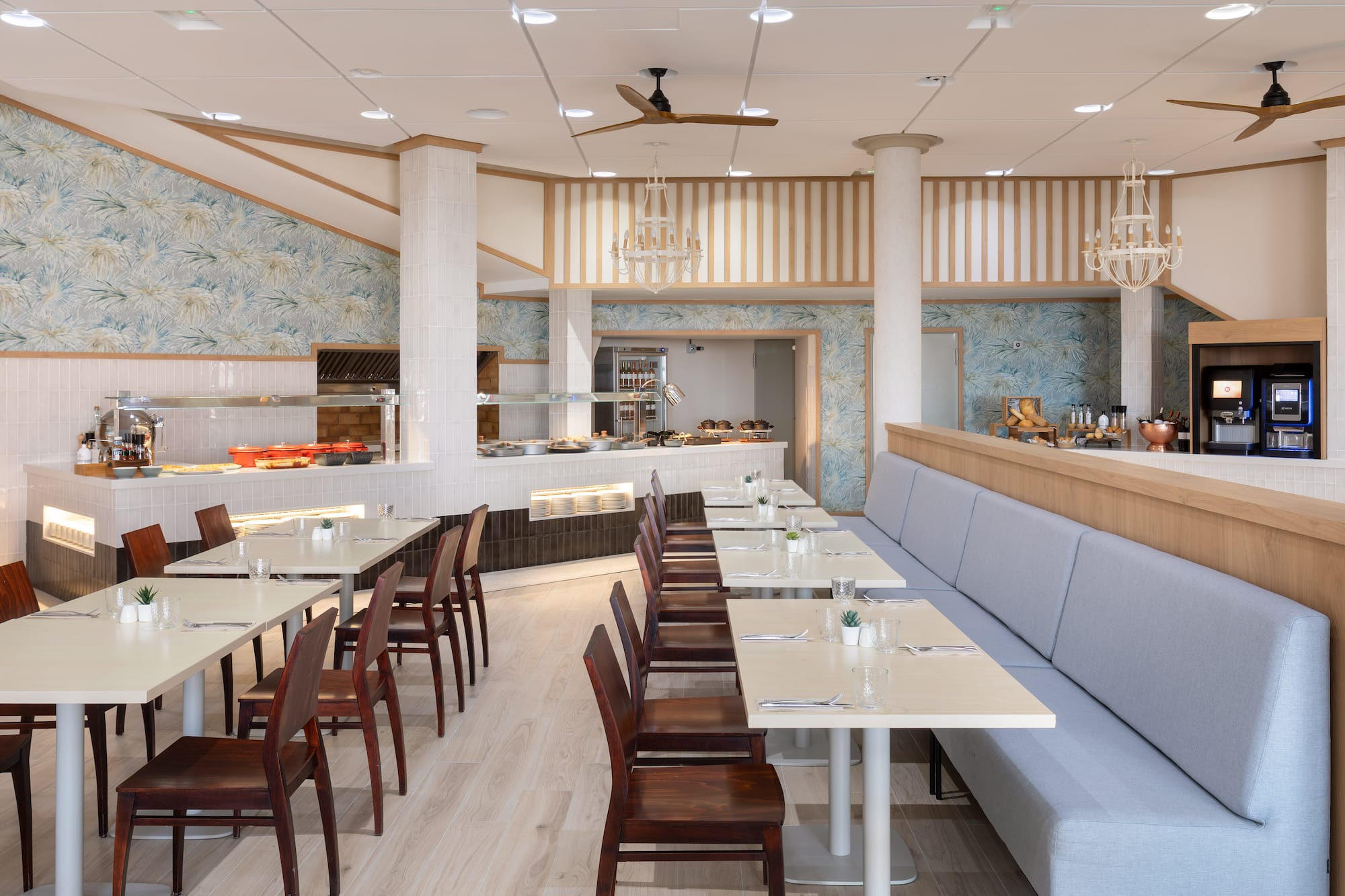Hotel buffet restaurant with dining tables, banquette seating, and serving area.