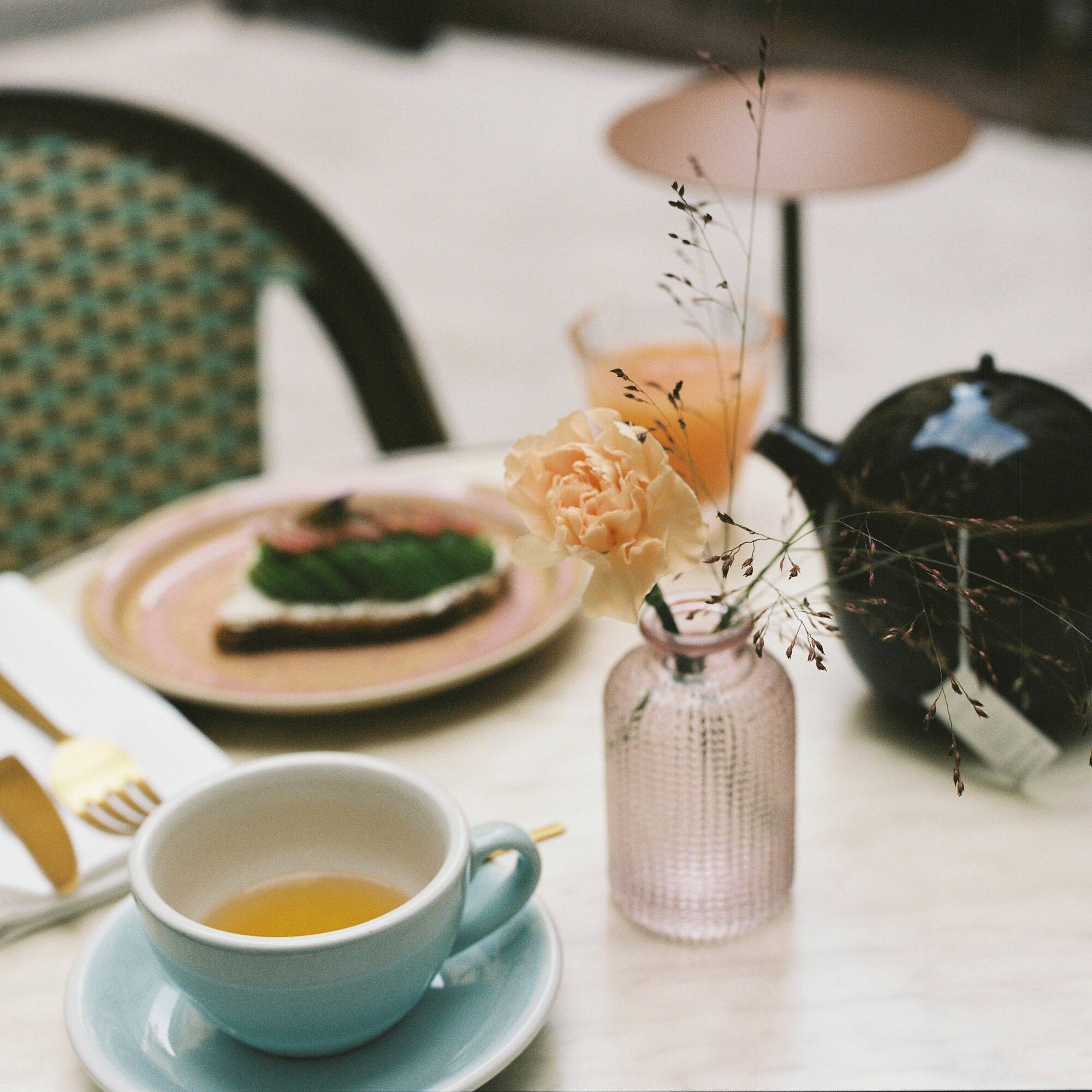 a cup of tea and a plate of food on a table