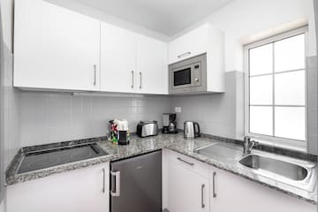 a kitchen with white cabinets and appliances