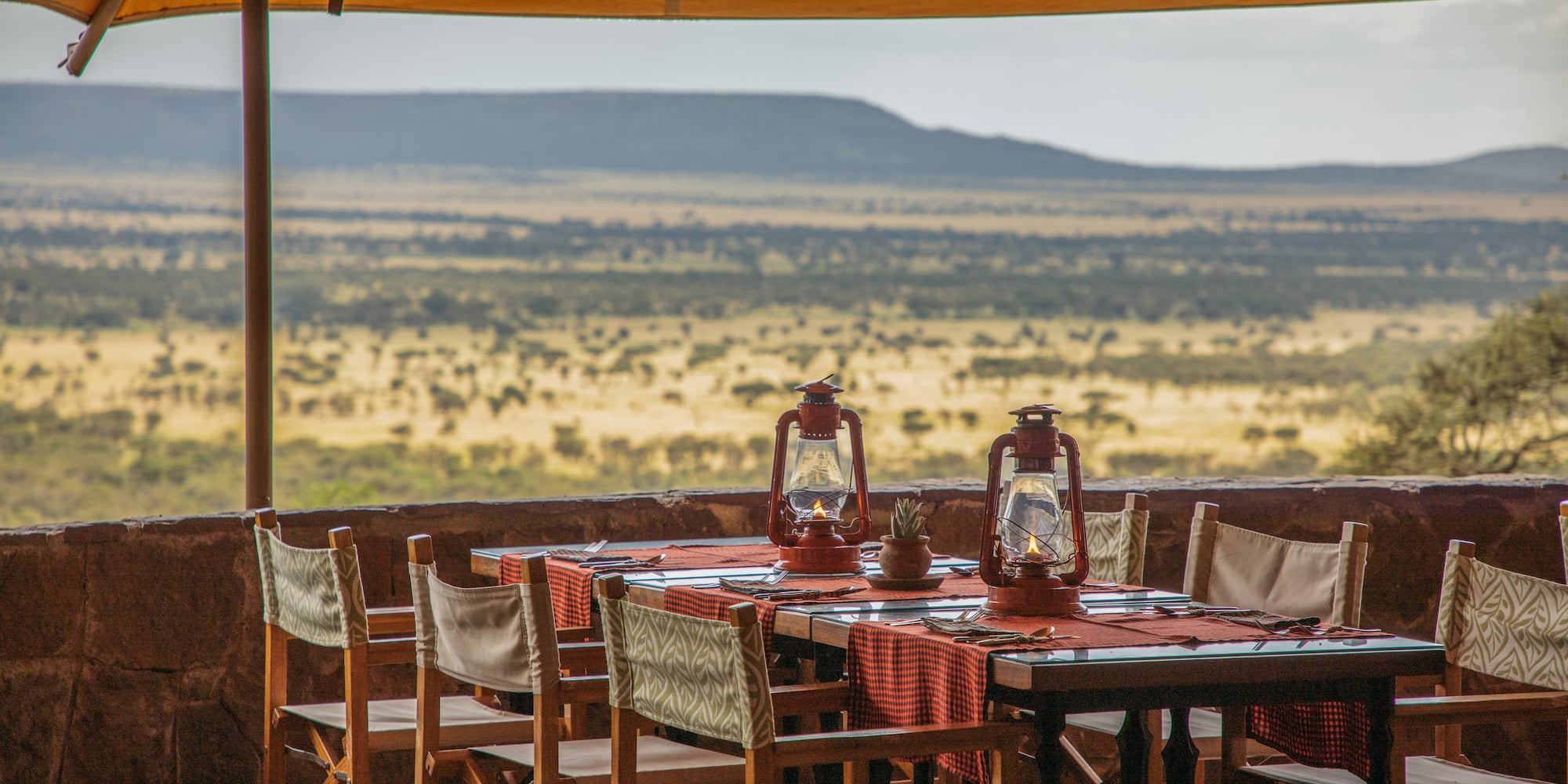 a table with chairs and lanterns on it.