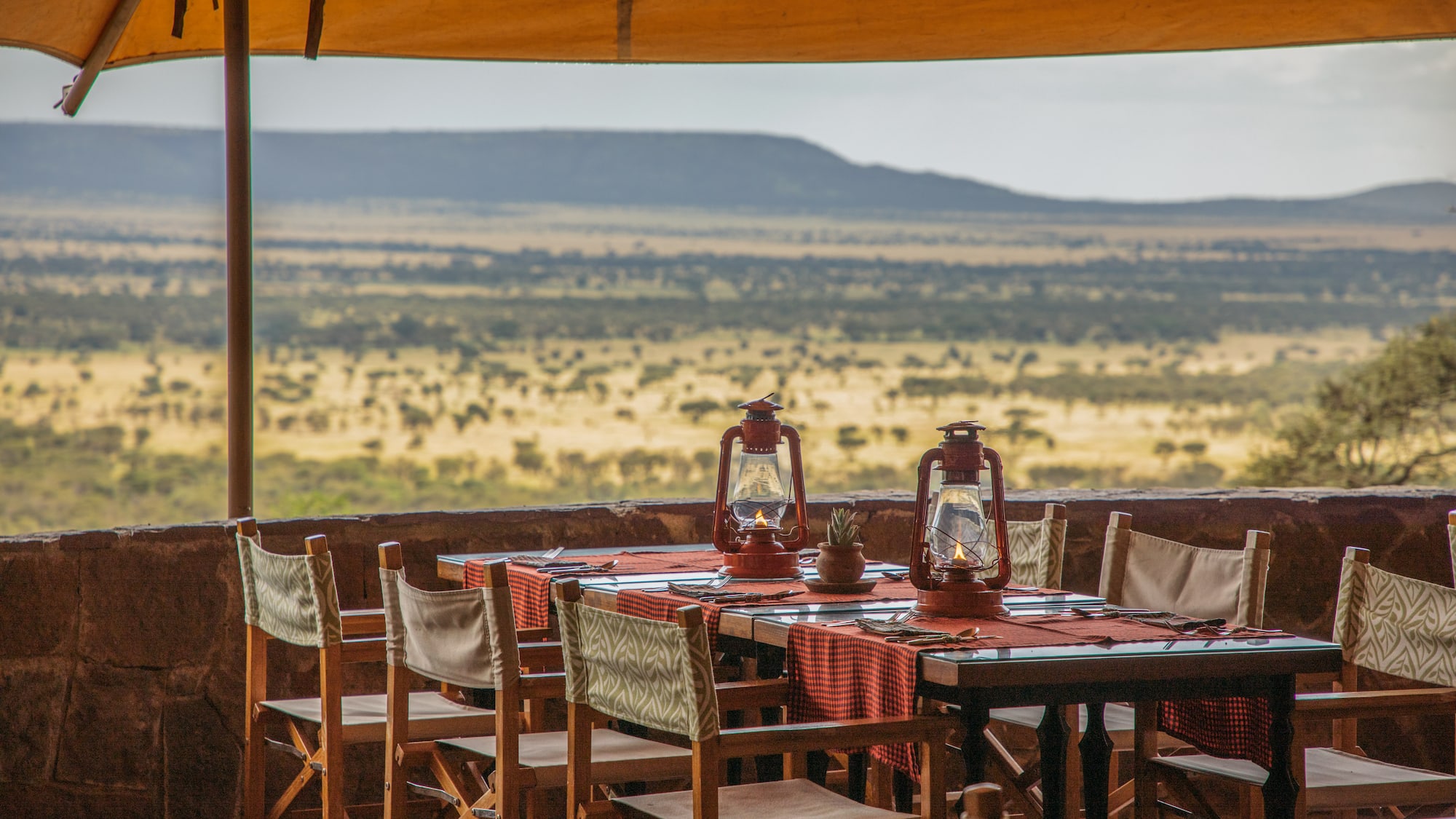 a table with chairs and lanterns on it.