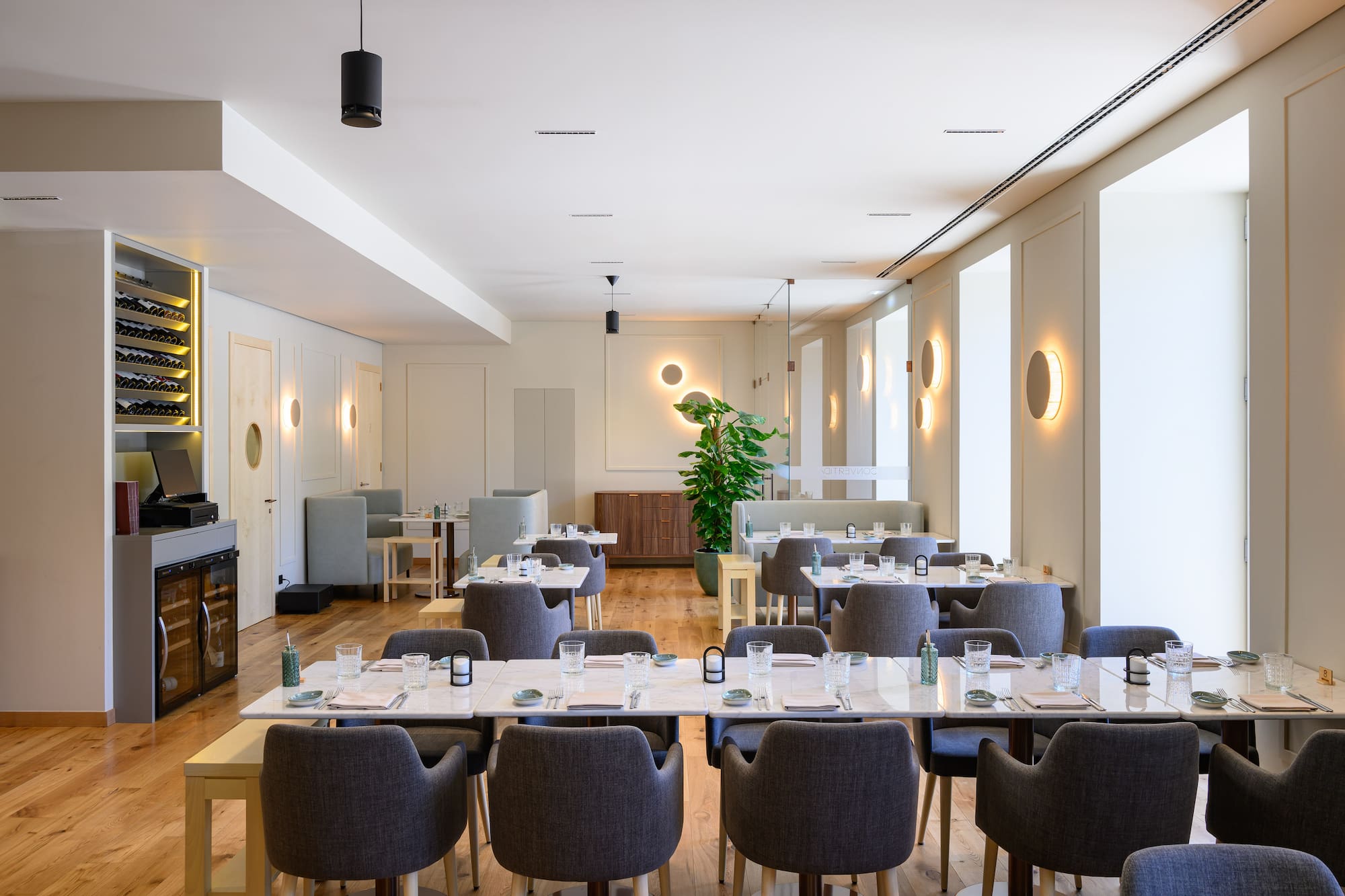 Modern restaurant interior with marble-topped tables, grey chairs, and ambient lighting. - INNSiDE Braga Centro, Braga