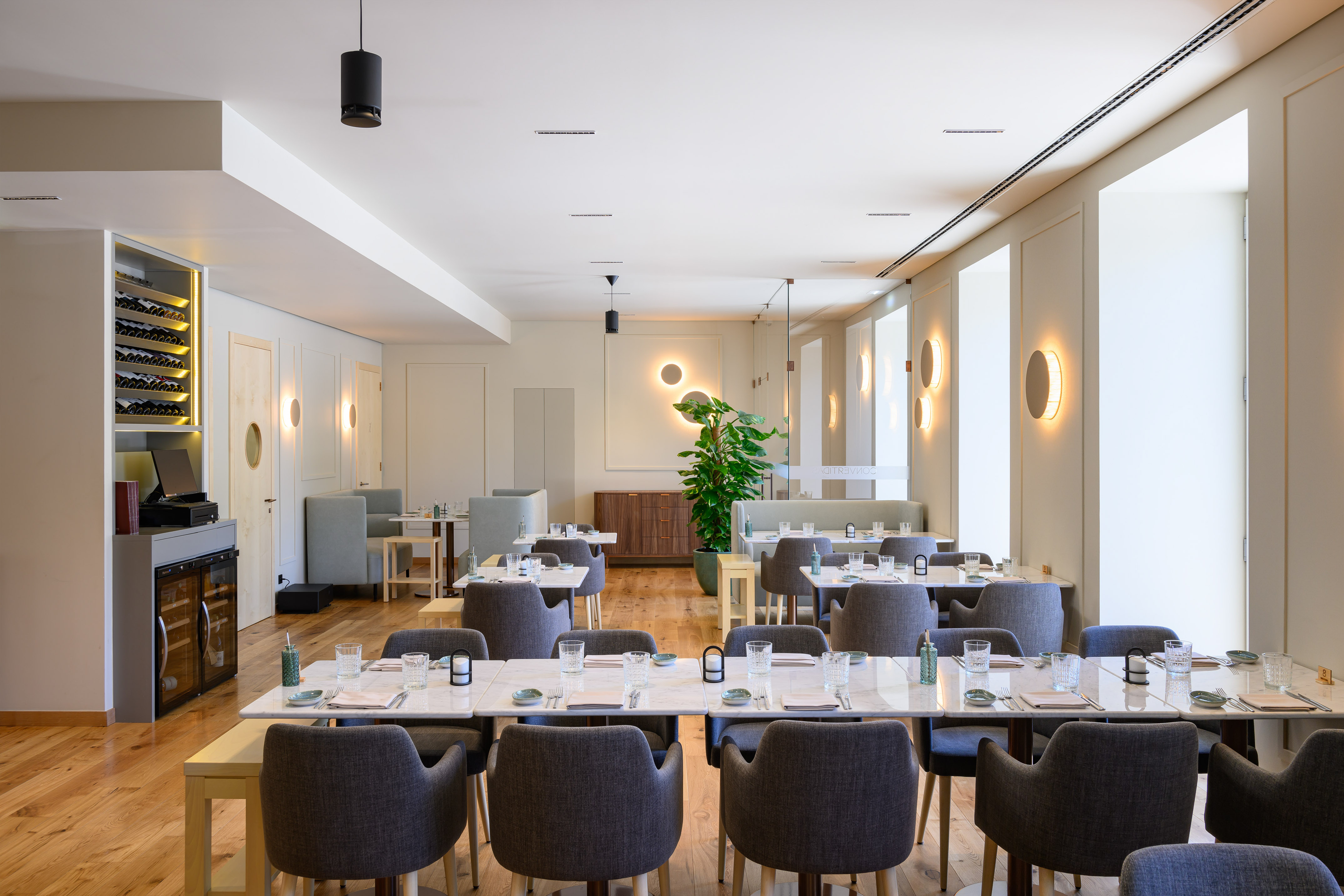 Modern restaurant interior with marble-topped tables, grey chairs, and ambient lighting. - INNSiDE Braga Centro, Braga