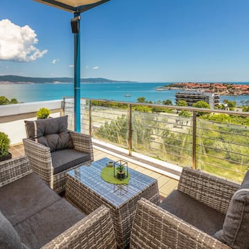 a patio with chairs and a table overlooking water