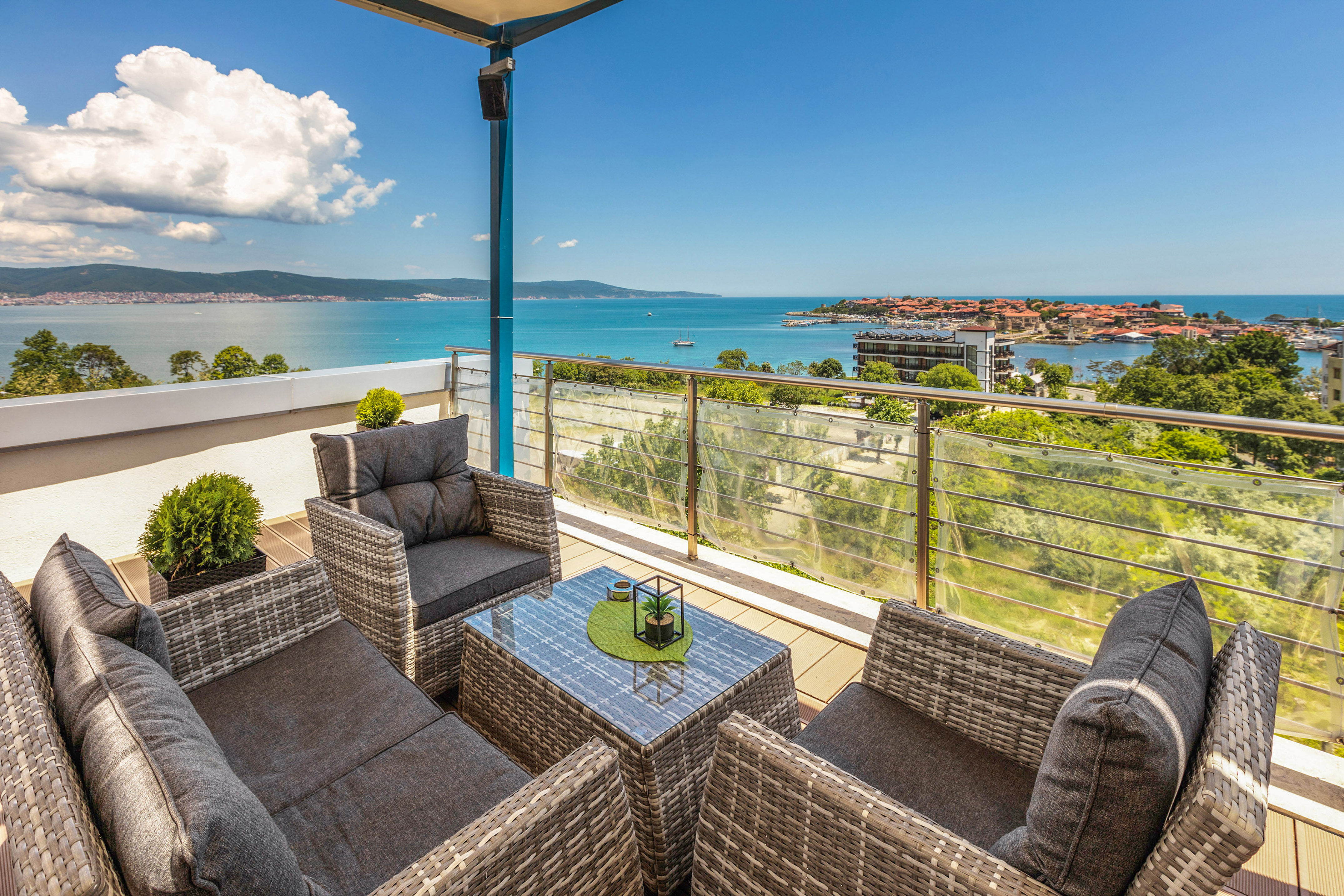 a patio with chairs and a table overlooking water