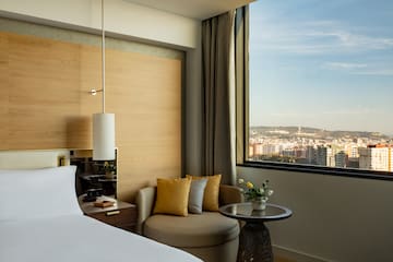 a room with a bed and a chair and a table