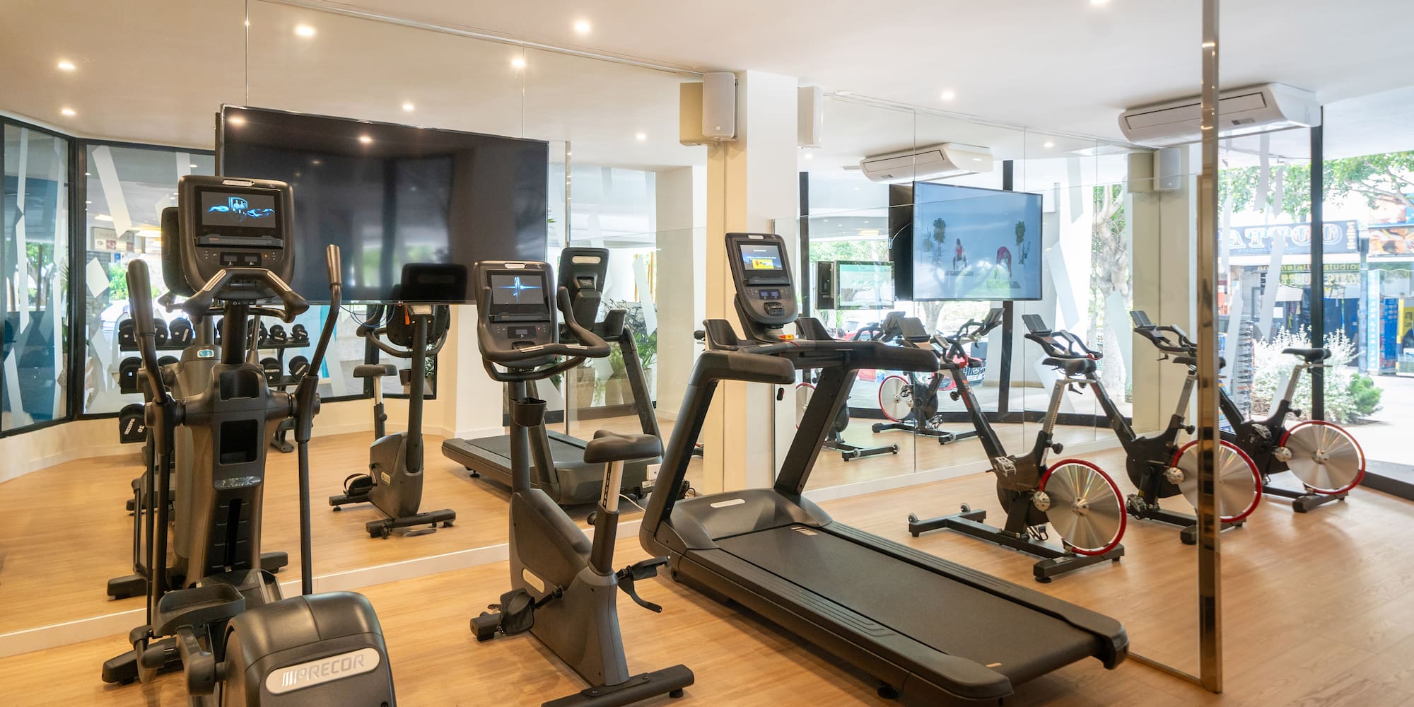 a room with exercise machines and a large screen