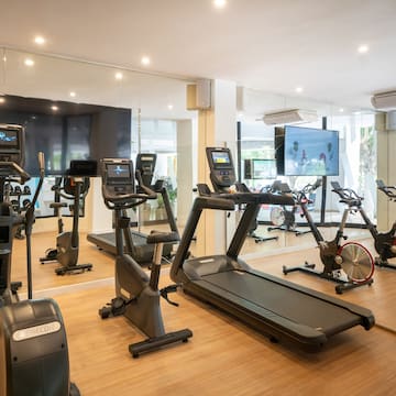 a room with exercise machines and a large screen