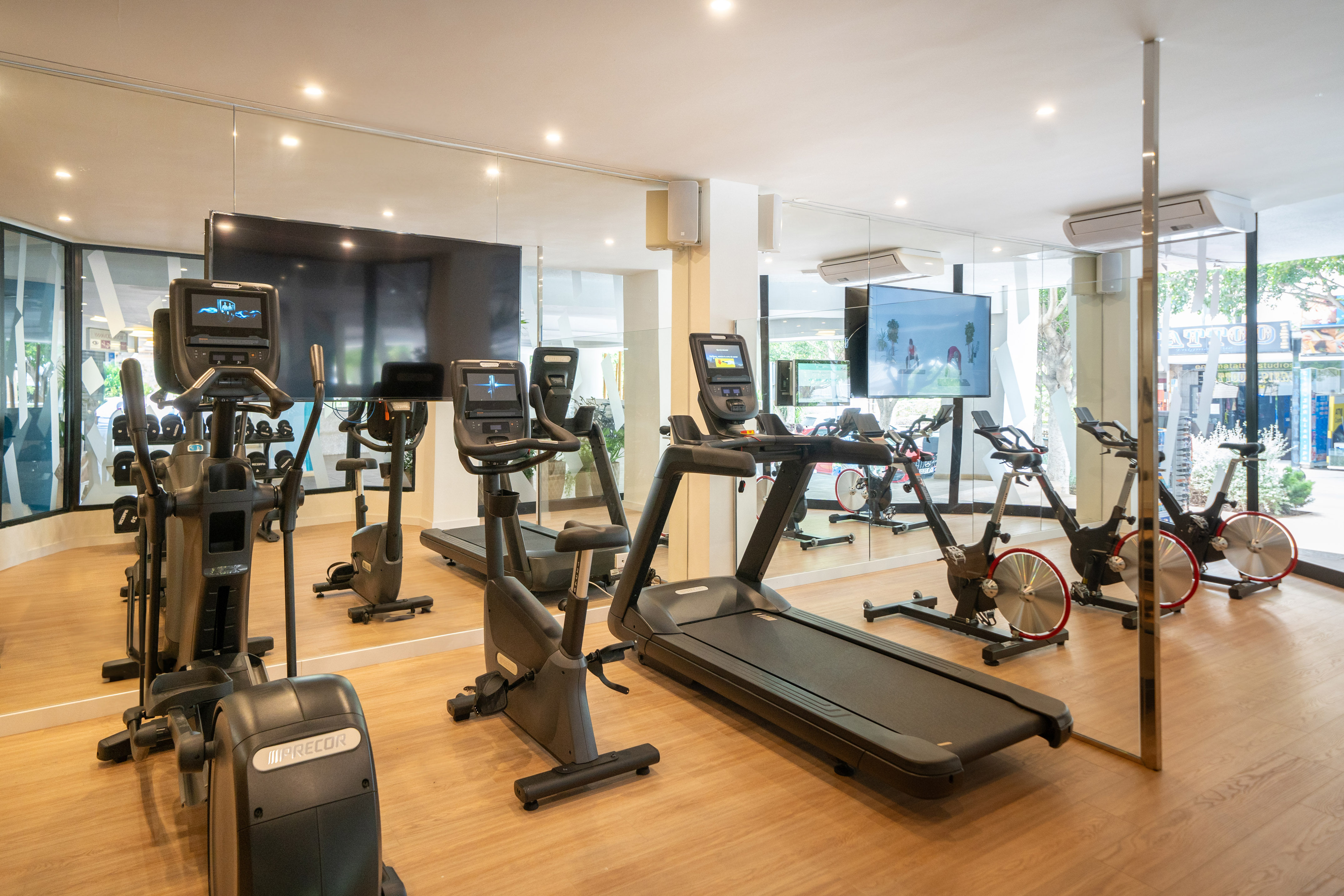 a room with exercise machines and a large screen