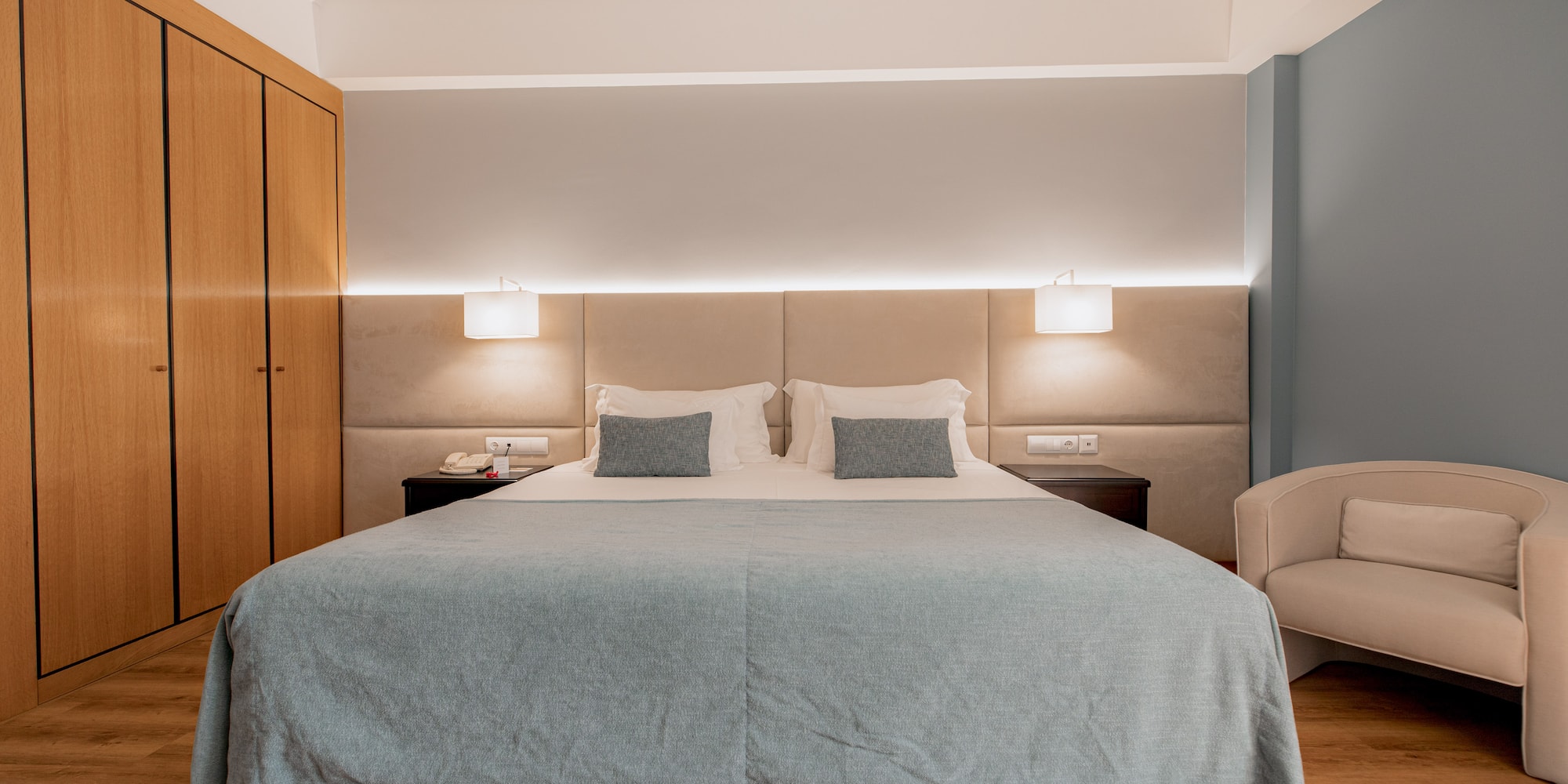 a bed with a chair and a cabinet