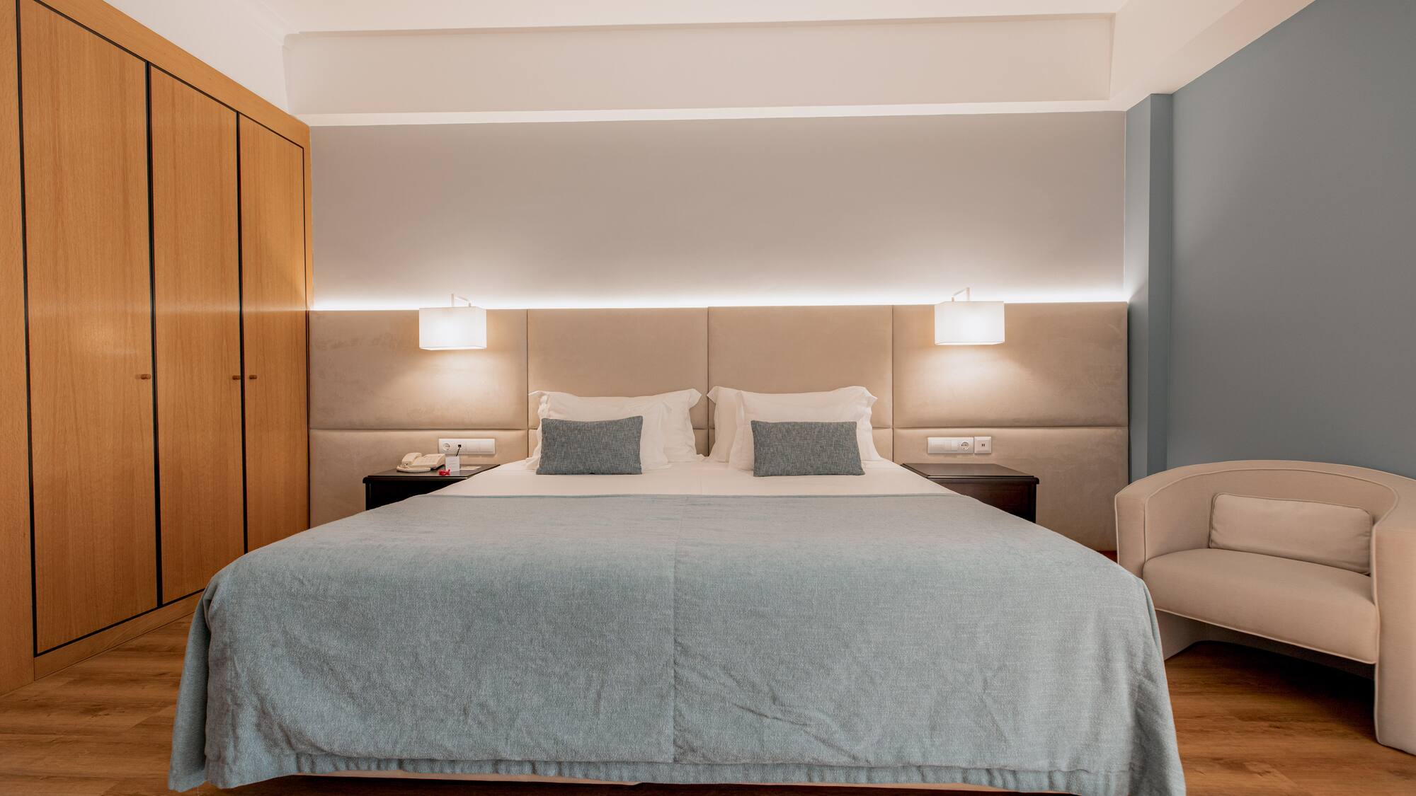 a bed with a chair and a cabinet