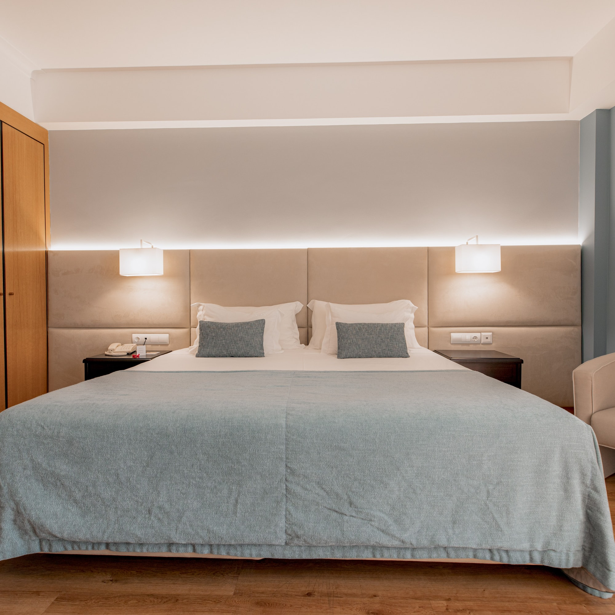 a bed with a chair and a cabinet