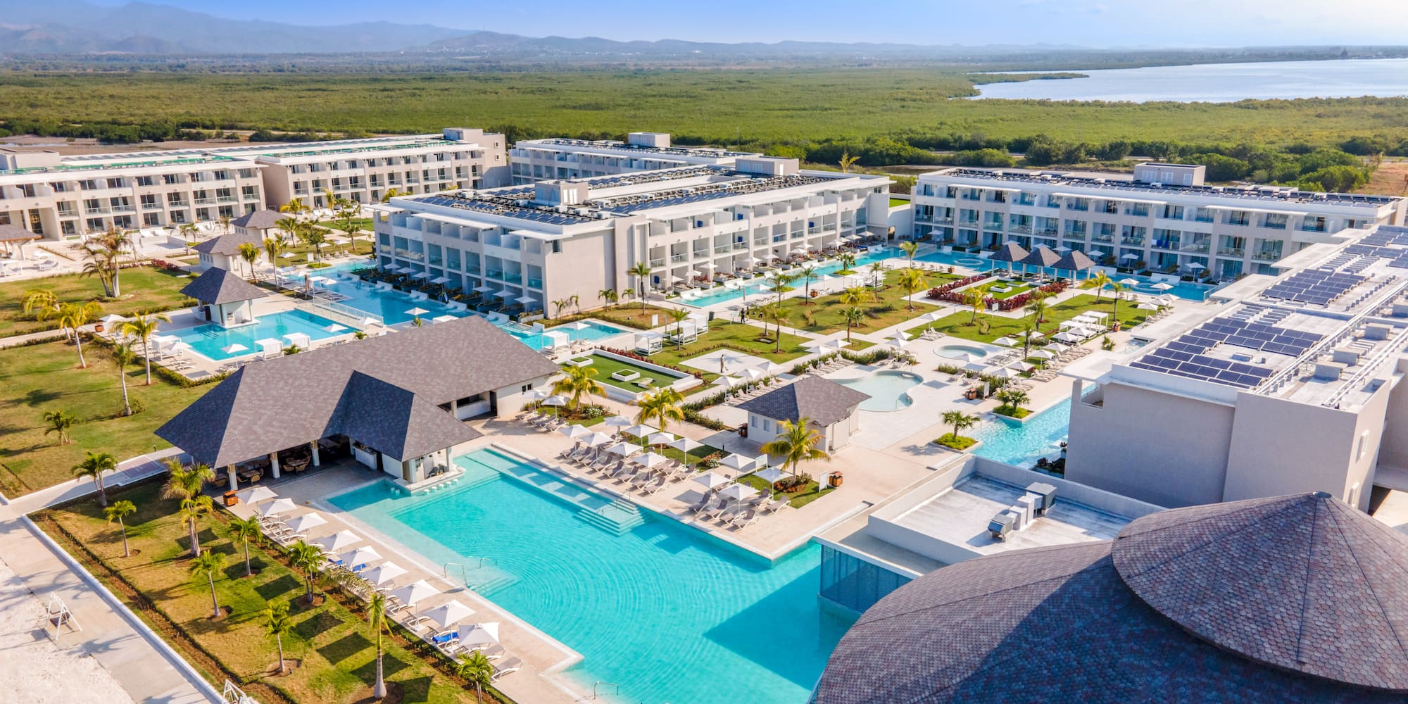 a swimming pool and buildings with trees and water in the background