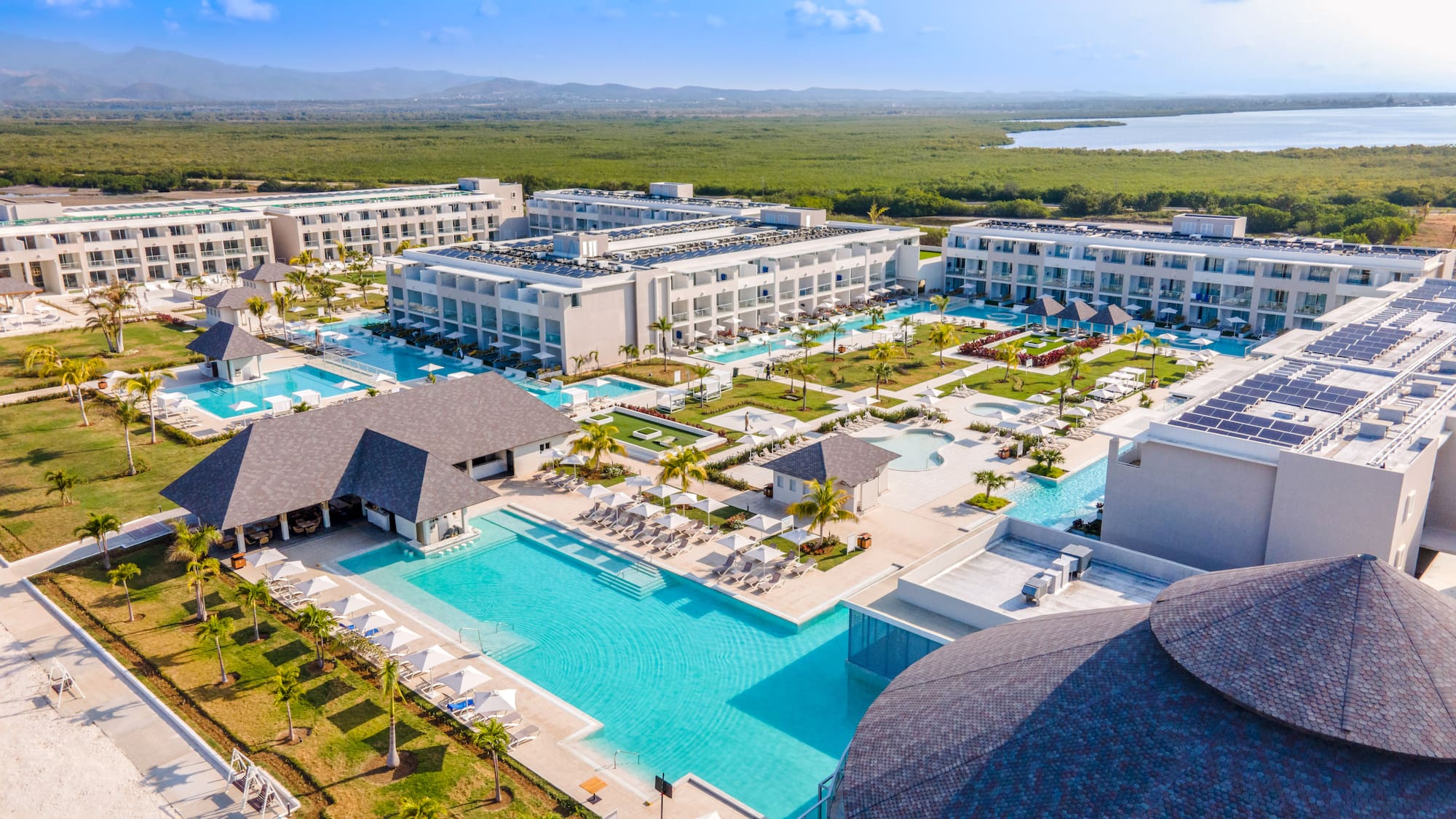 a swimming pool and buildings with trees and water in the background