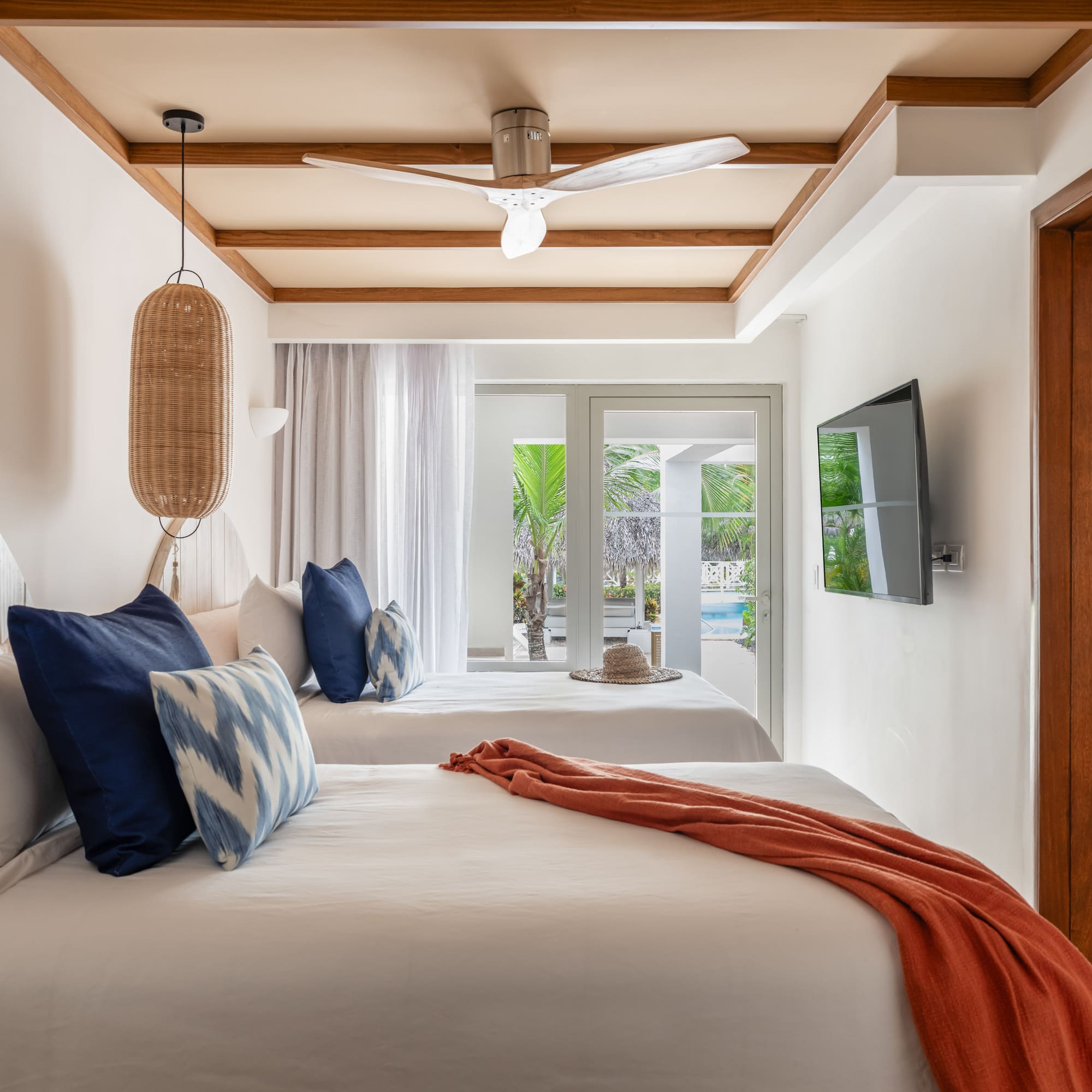 a room with two beds and a ceiling fan