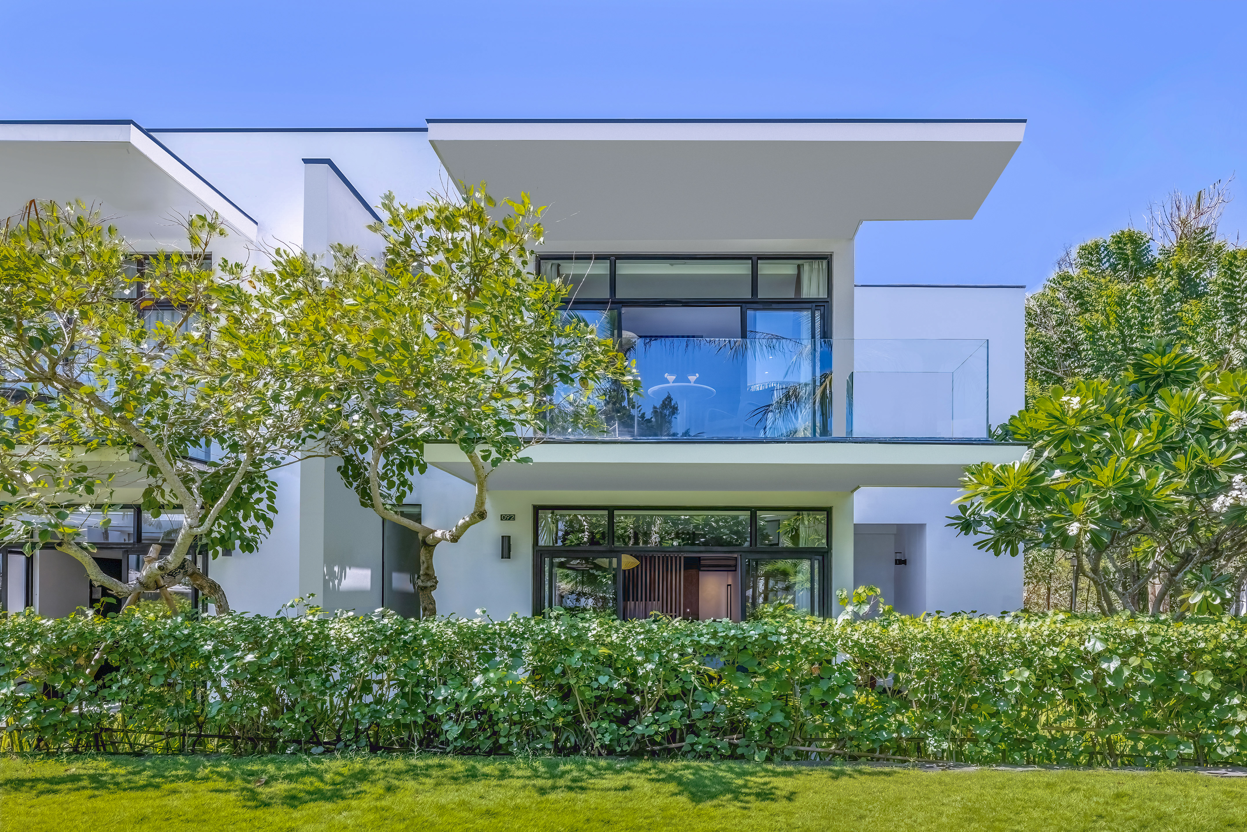 a white house with trees and bushes