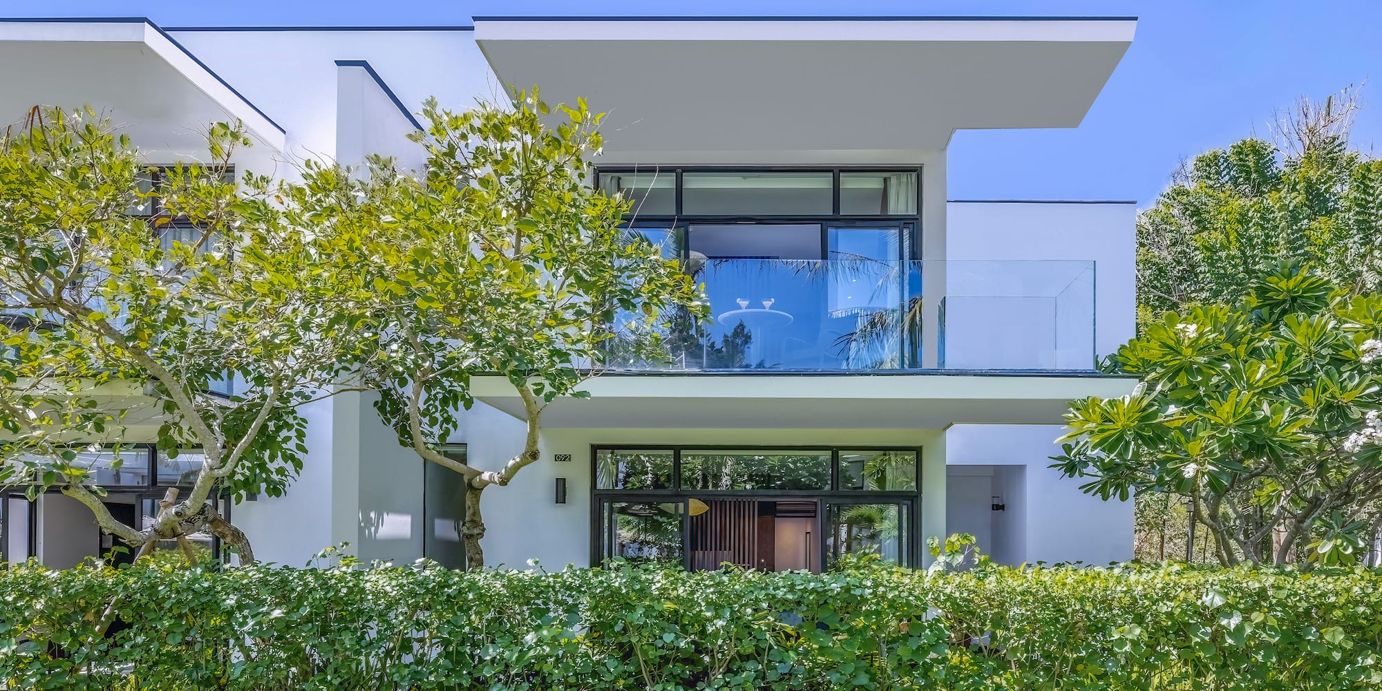 a white house with trees and bushes