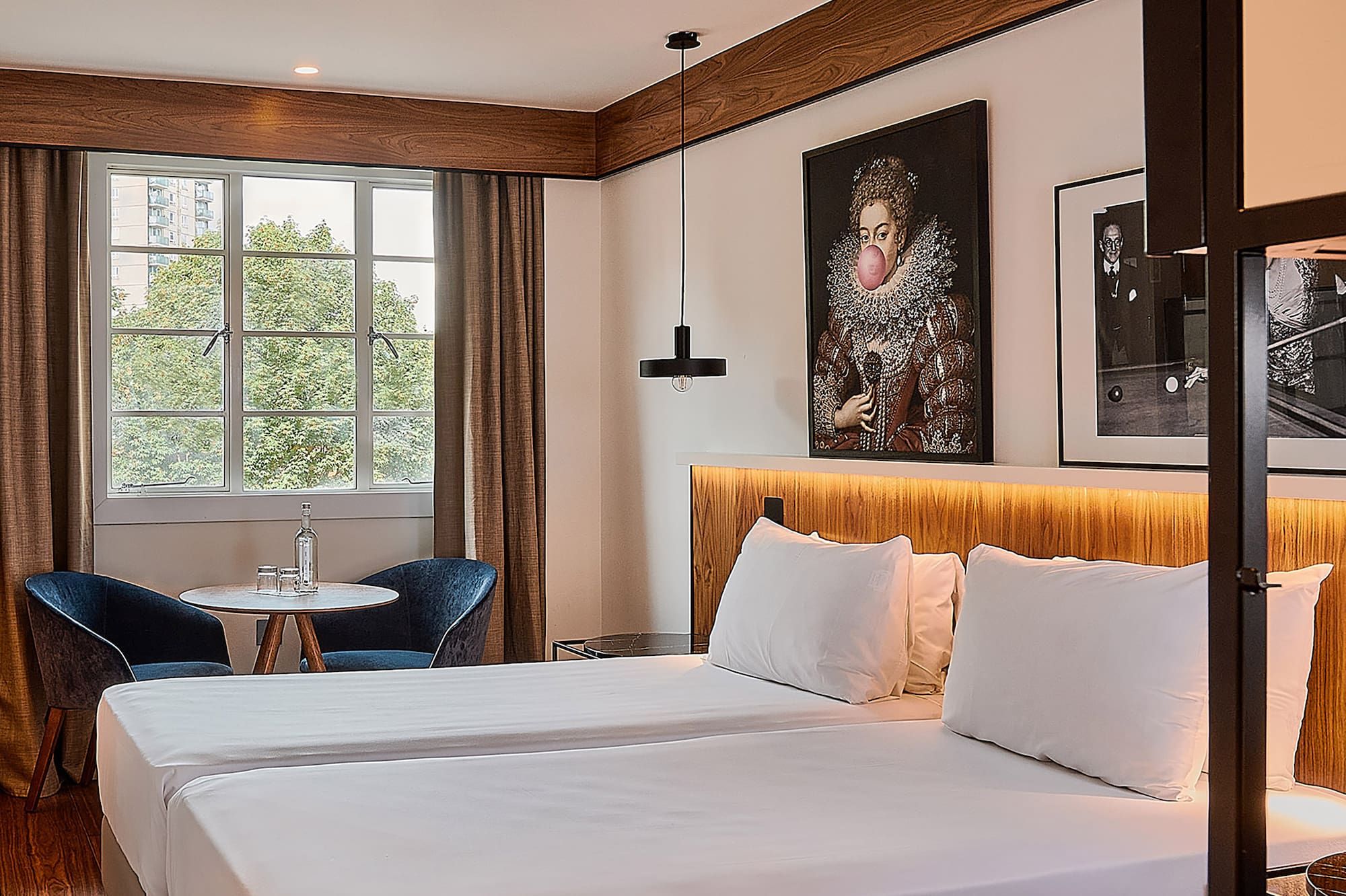 a room with two beds and a table and chairs