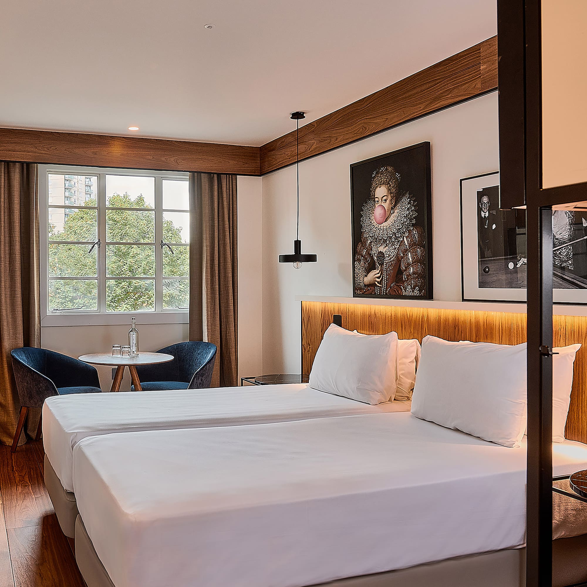 a room with two beds and a table and chairs