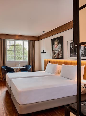 a room with two beds and a table and chairs