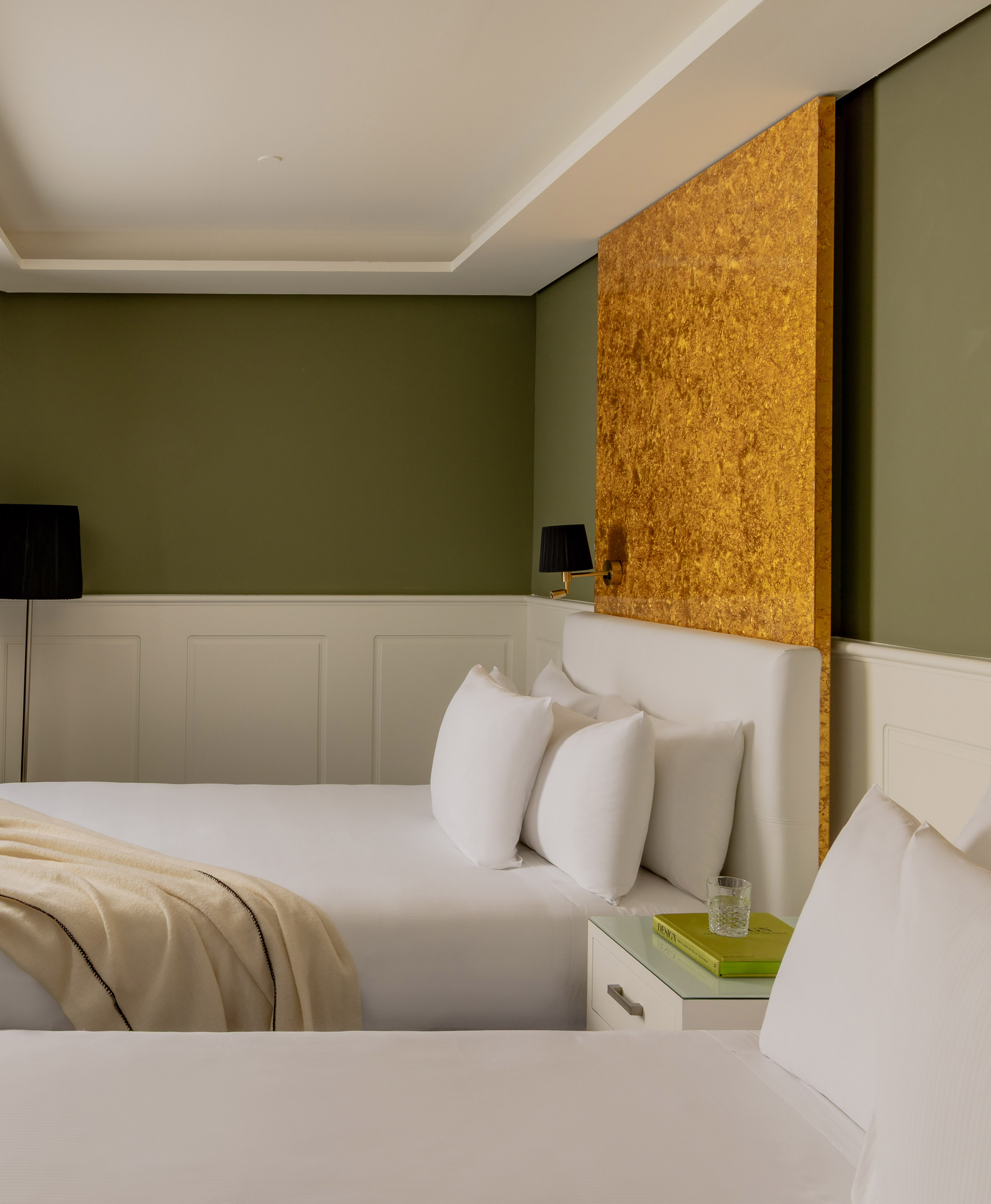 a room with two beds and a lamp