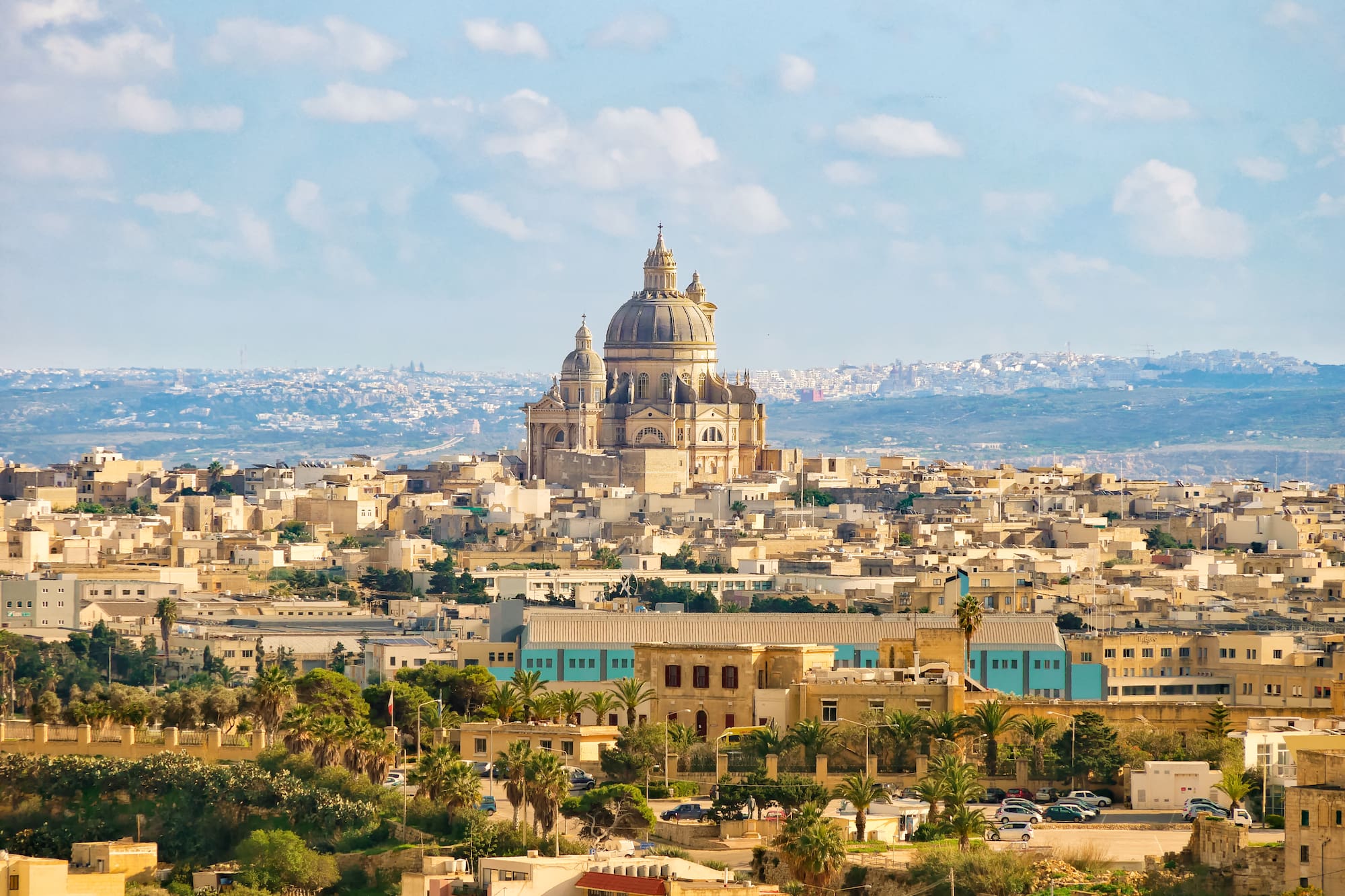 Aerial view of a historic Maltese city with a grand domed cathedral.